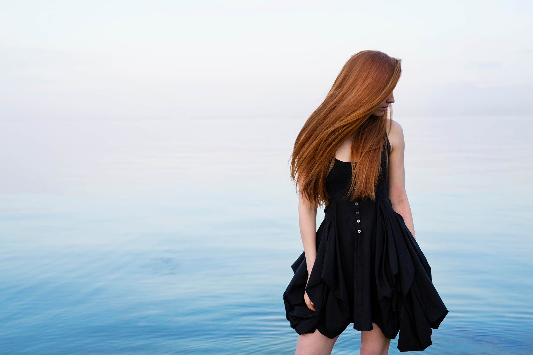 Redhead woman in black dress by the water HD Wallpaper