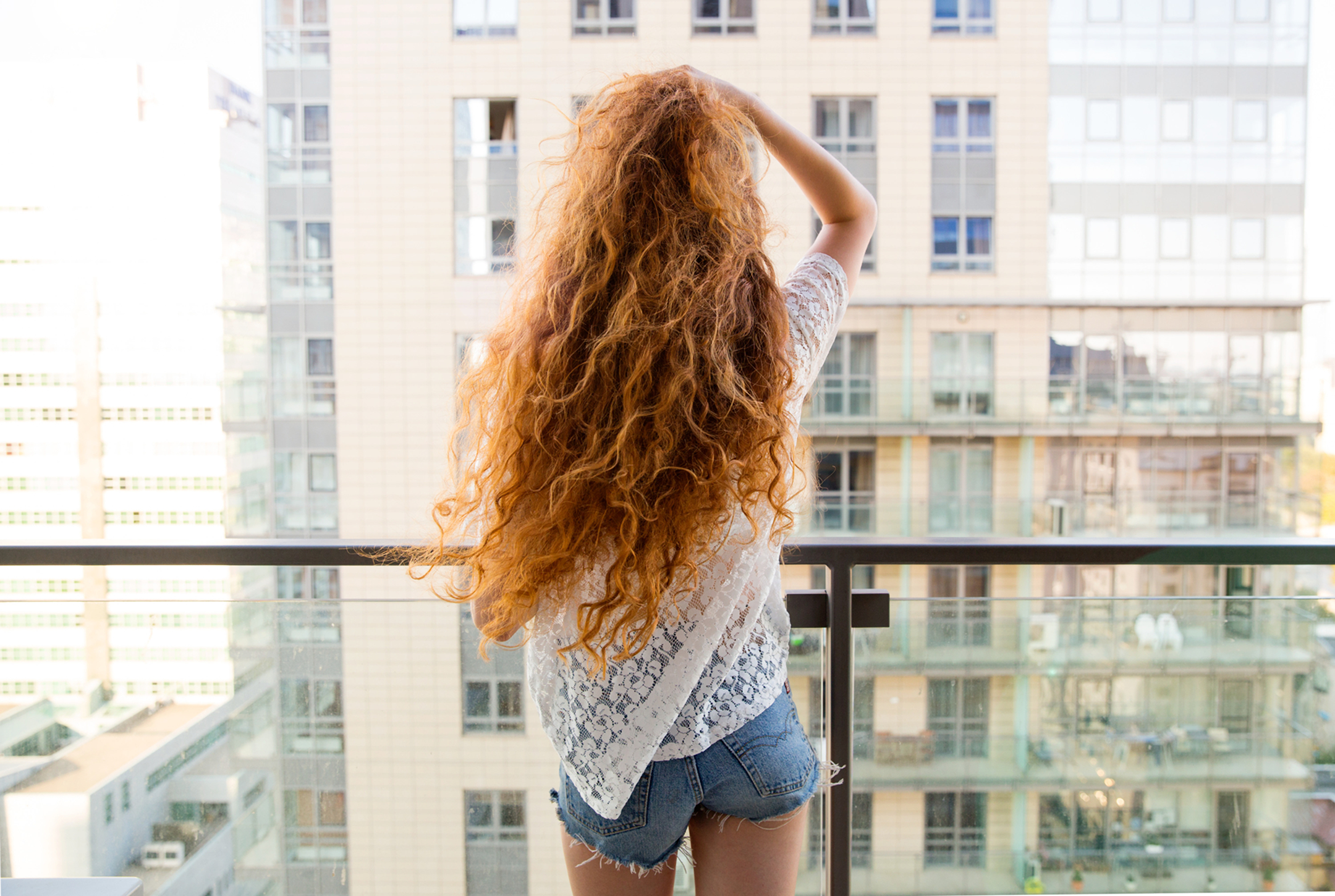 Woman with long red hair on a balcony HD Wallpaper