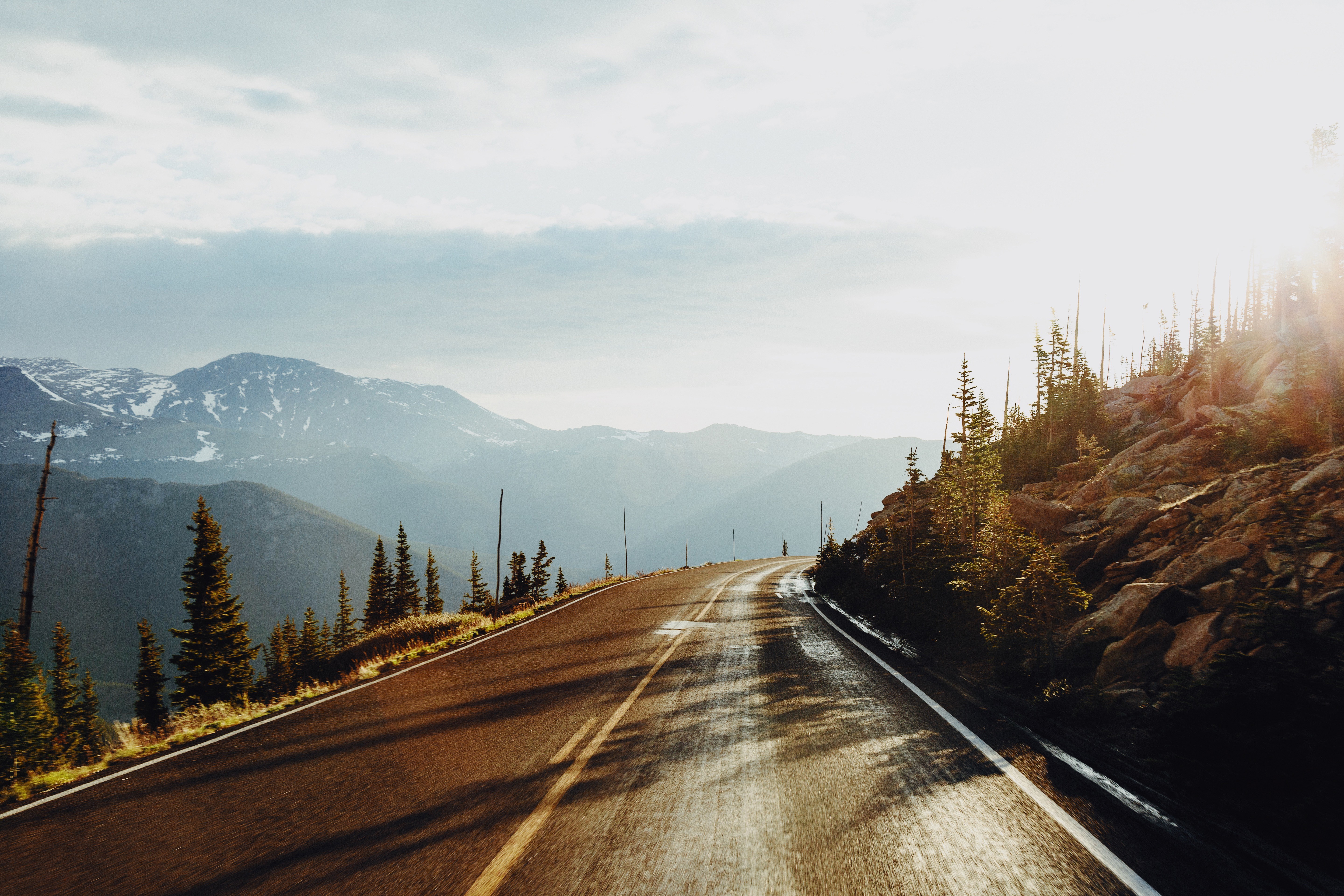 Scenic mountain road with sun rays HD Wallpaper