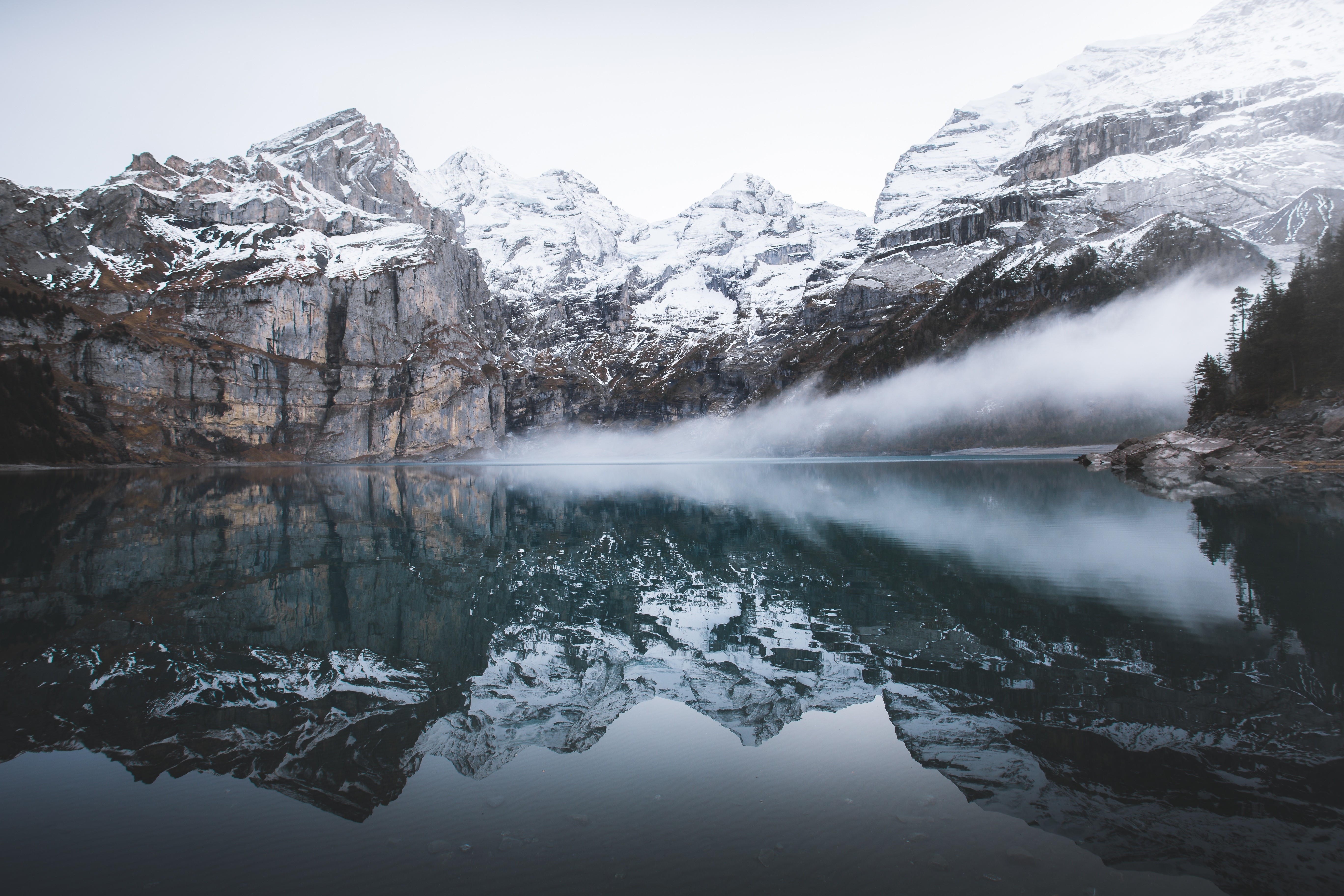 Snow-capped mountains reflected in a calm lake HD Wallpaper