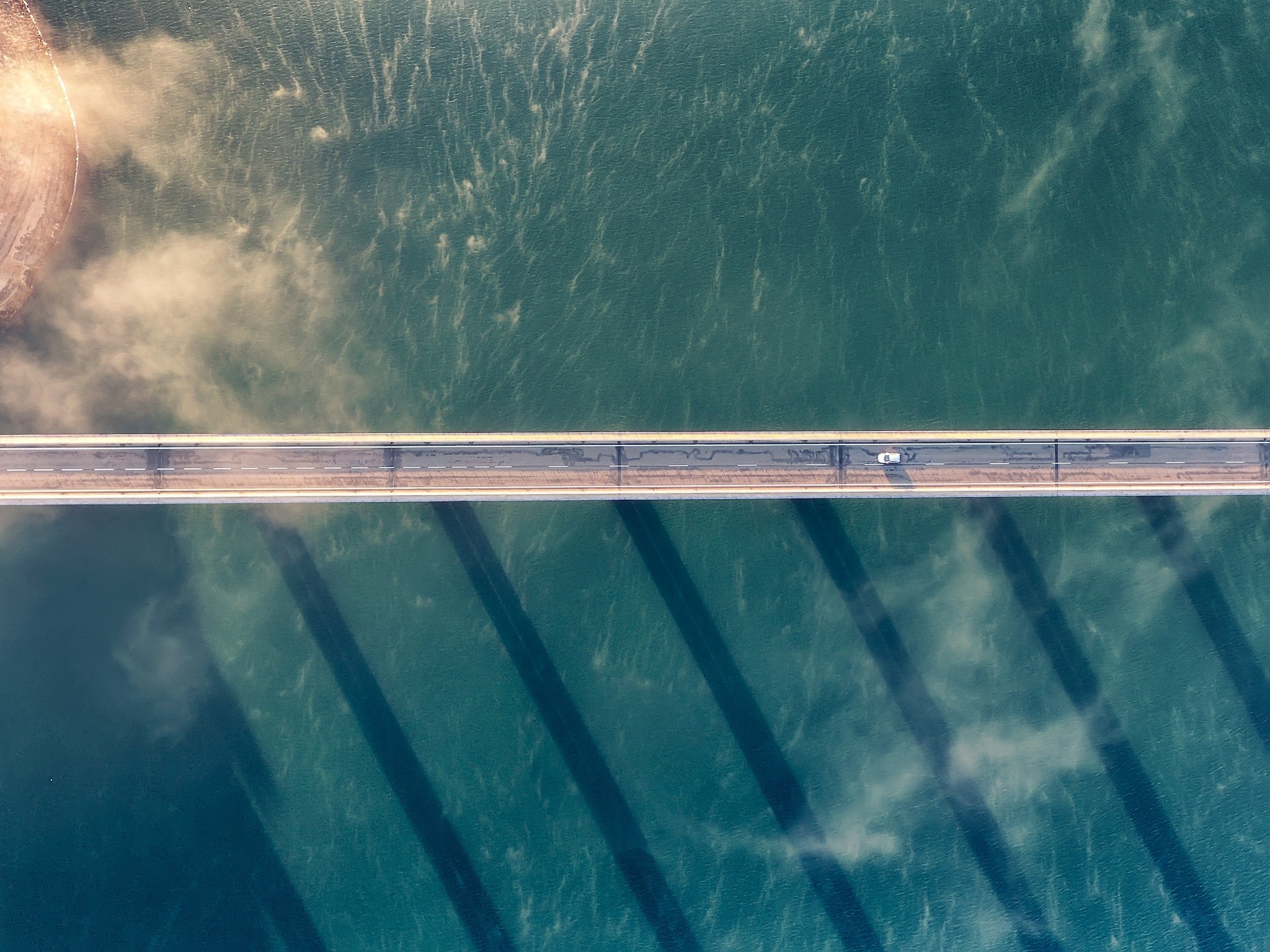 Aerial view of a bridge over water with a car HD Wallpaper
