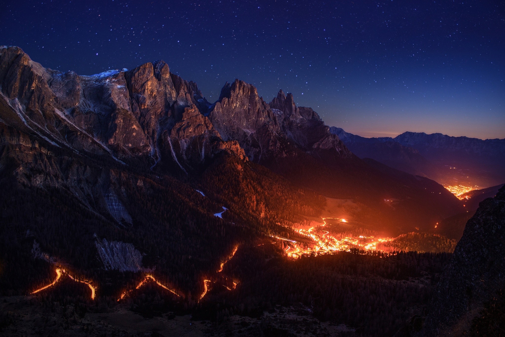Mountain valley village at night with stars and fire lights HD Wallpaper