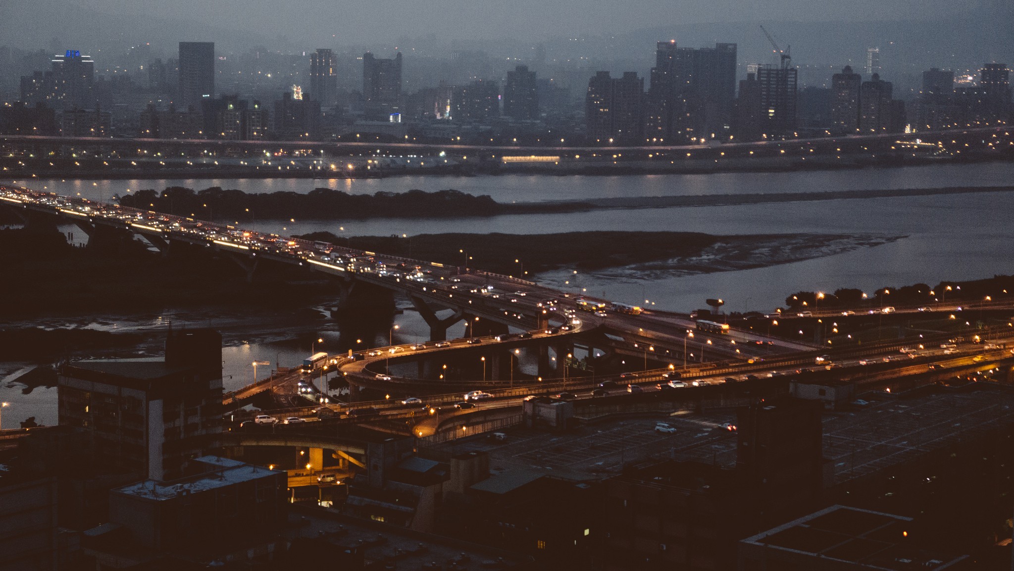Cityscape at night with traffic on bridges HD Wallpaper