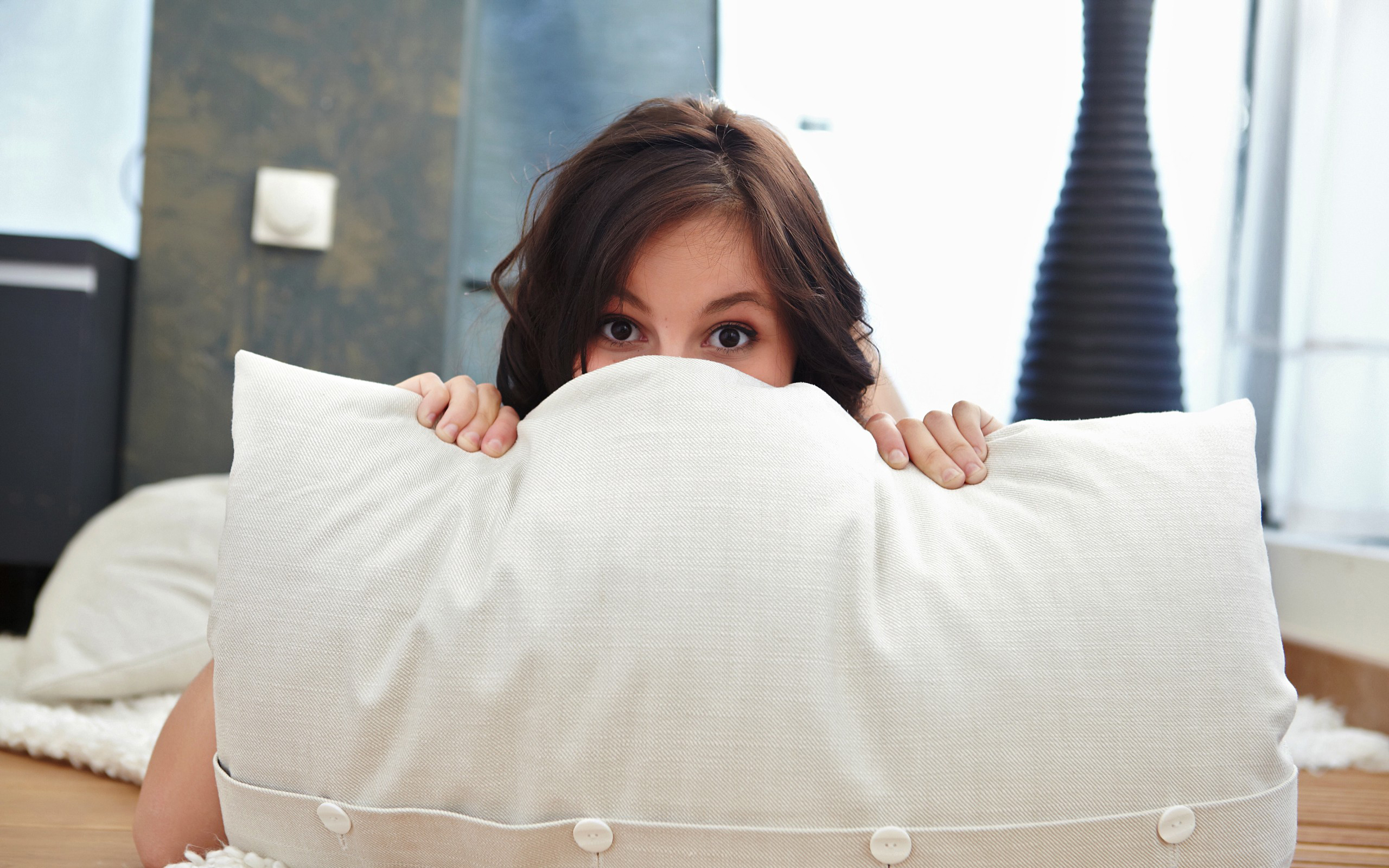 Woman peeking over a pillow HD Wallpaper