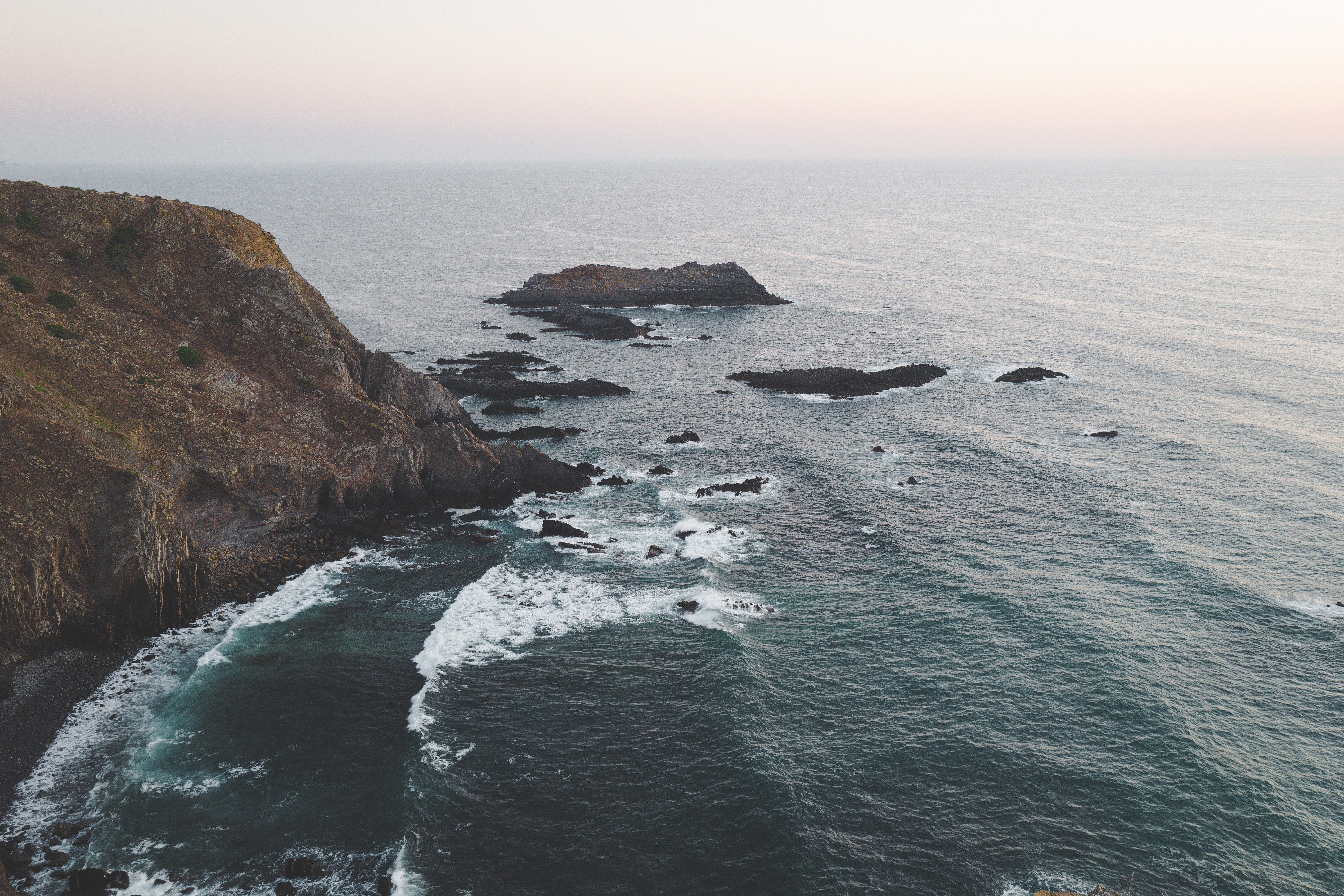 Rocky coastline with waves crashing against the shore HD Wallpaper
