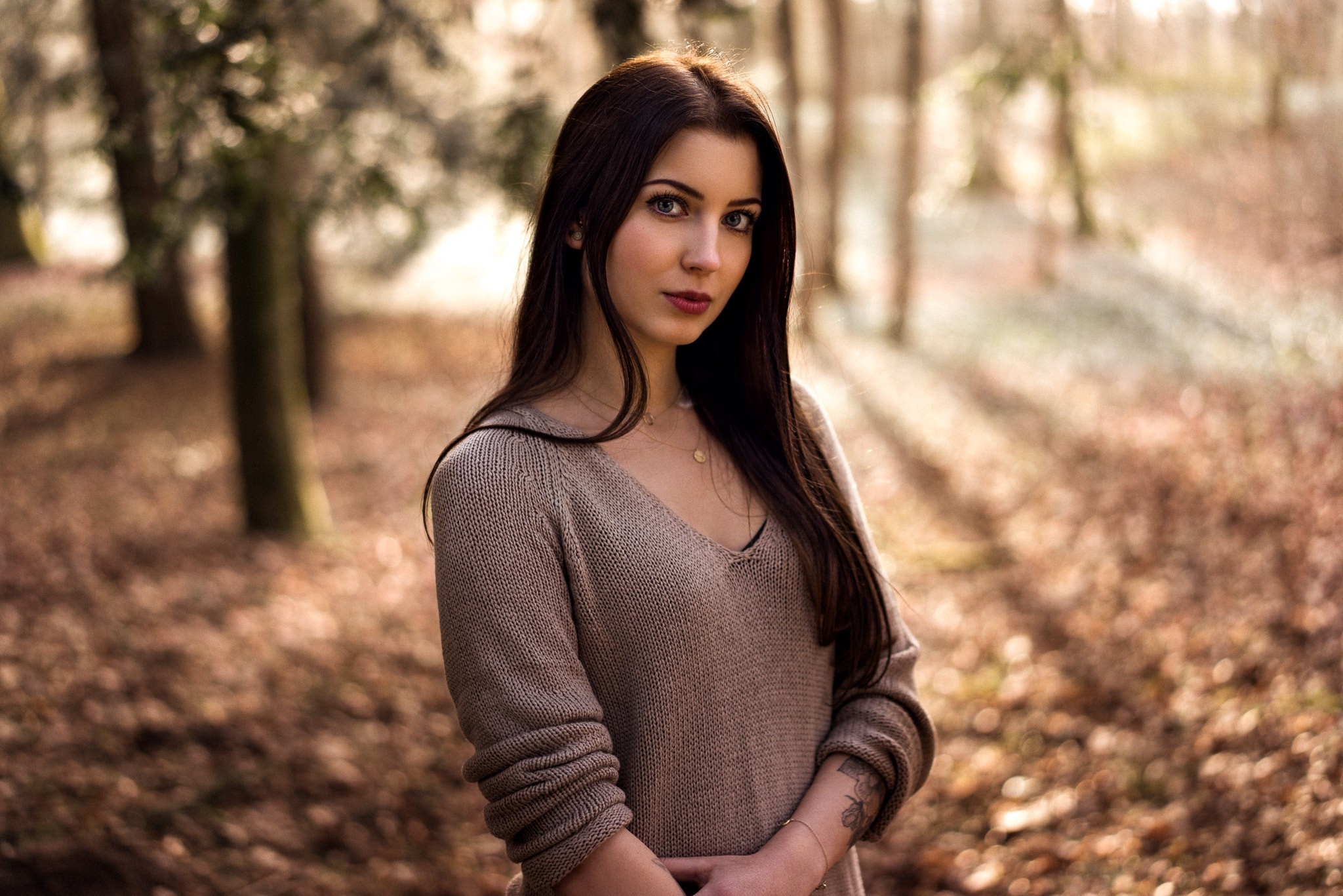 Woman with long brown hair in a forest HD Wallpaper