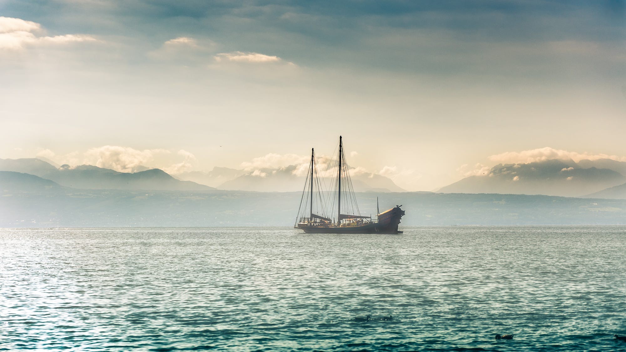 Sailboat on a lake with mountains in the background HD Wallpaper