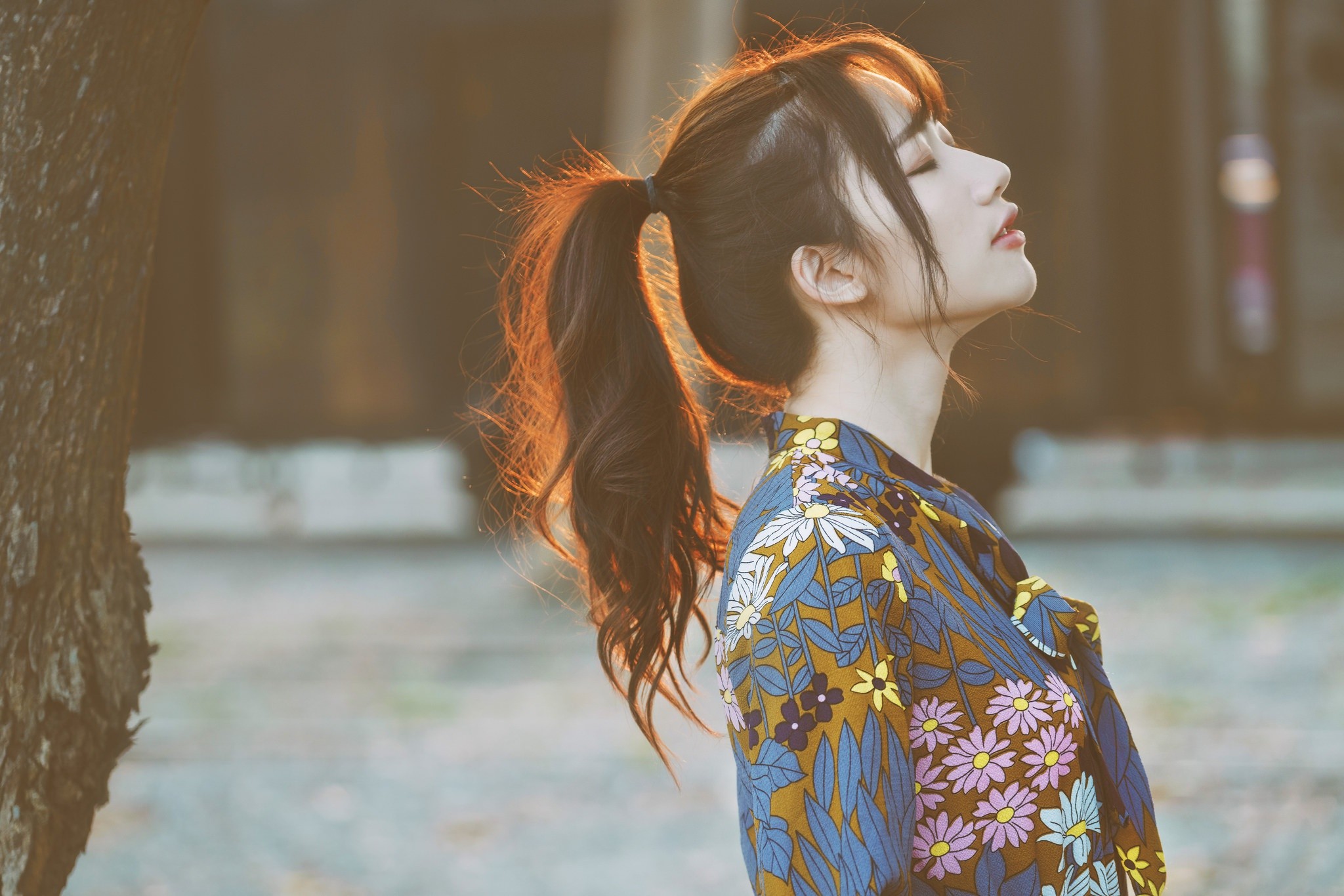 Asian woman with closed eyes in a floral shirt outdoors HD Wallpaper