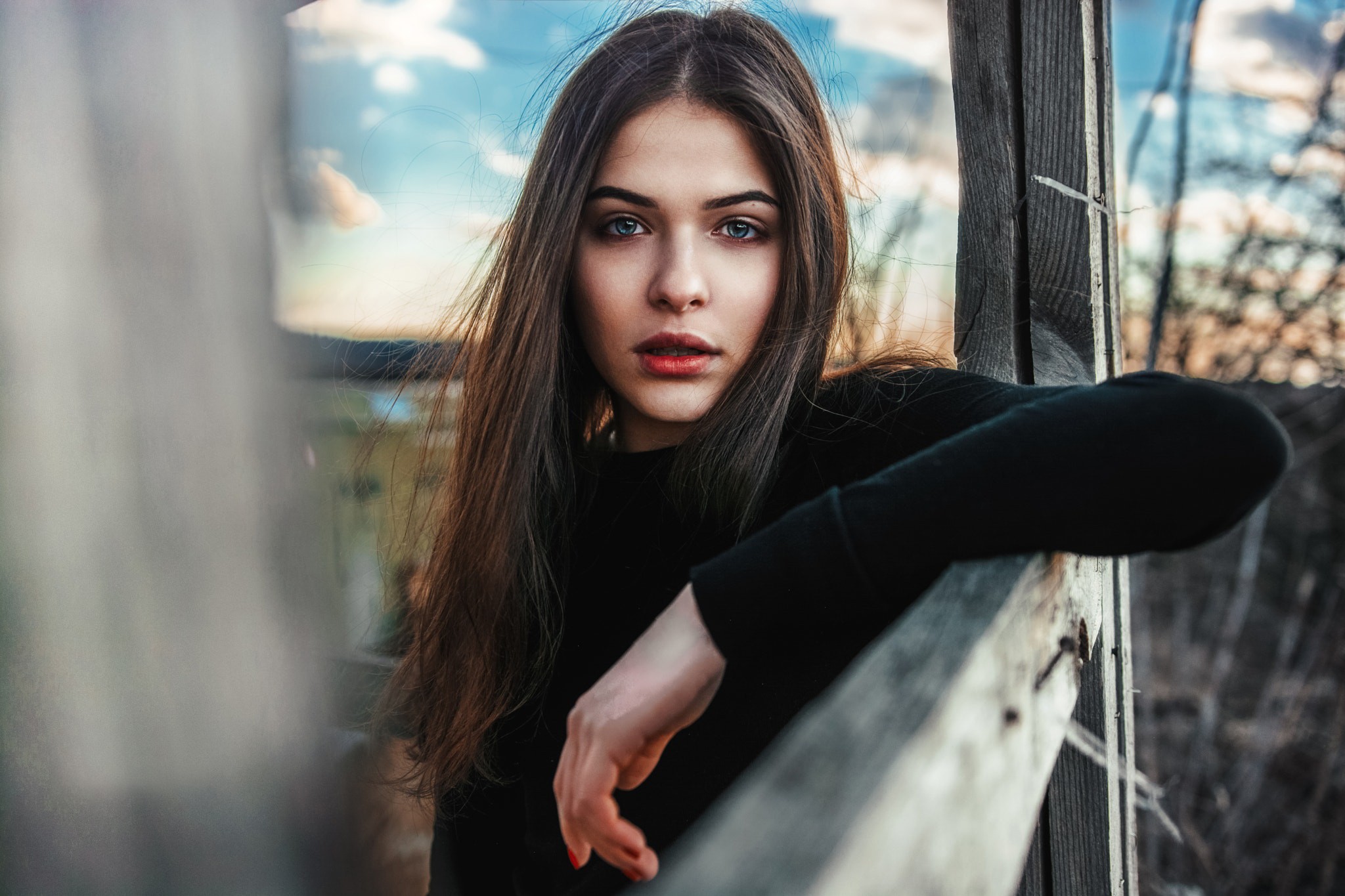 Woman in black clothing leaning on a wooden fence HD Wallpaper