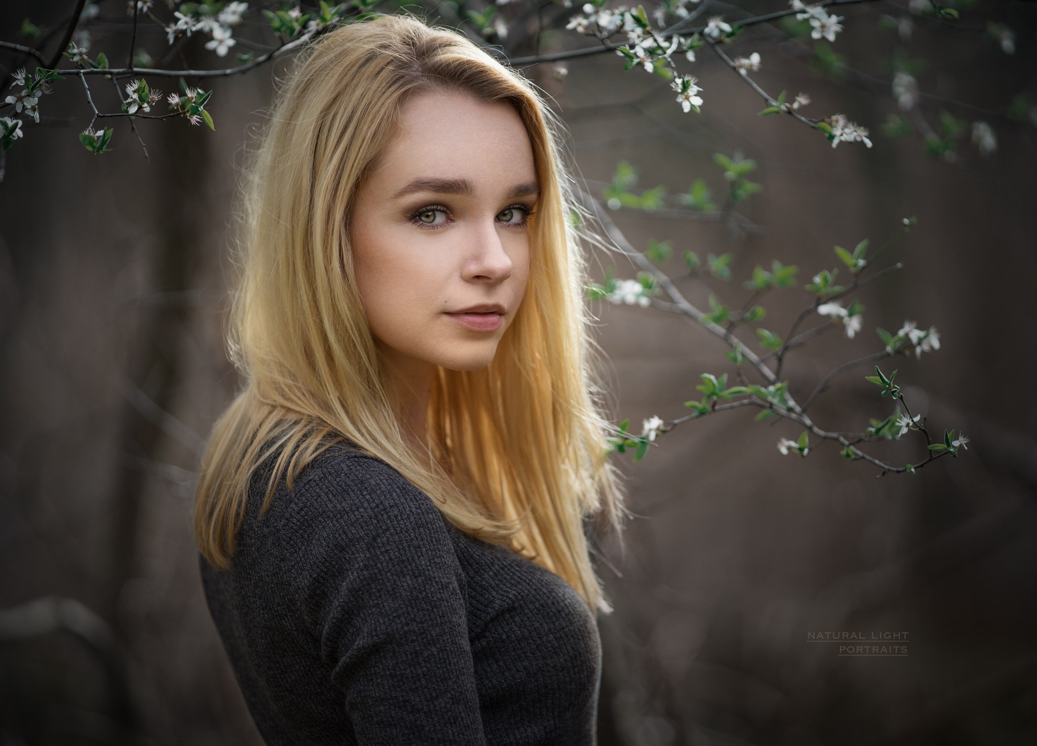 Woman with blonde hair in a grey sweater outdoors HD Wallpaper