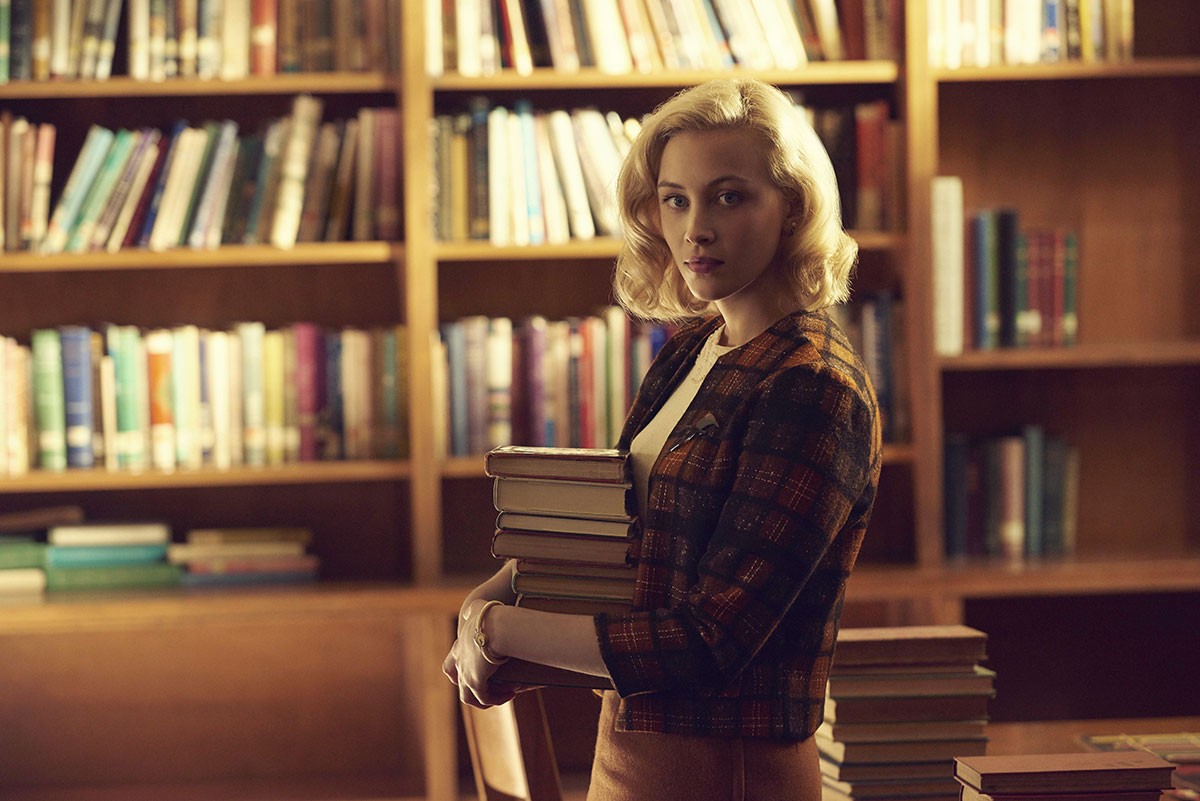 Sarah Gadon holding books in a library HD Wallpaper