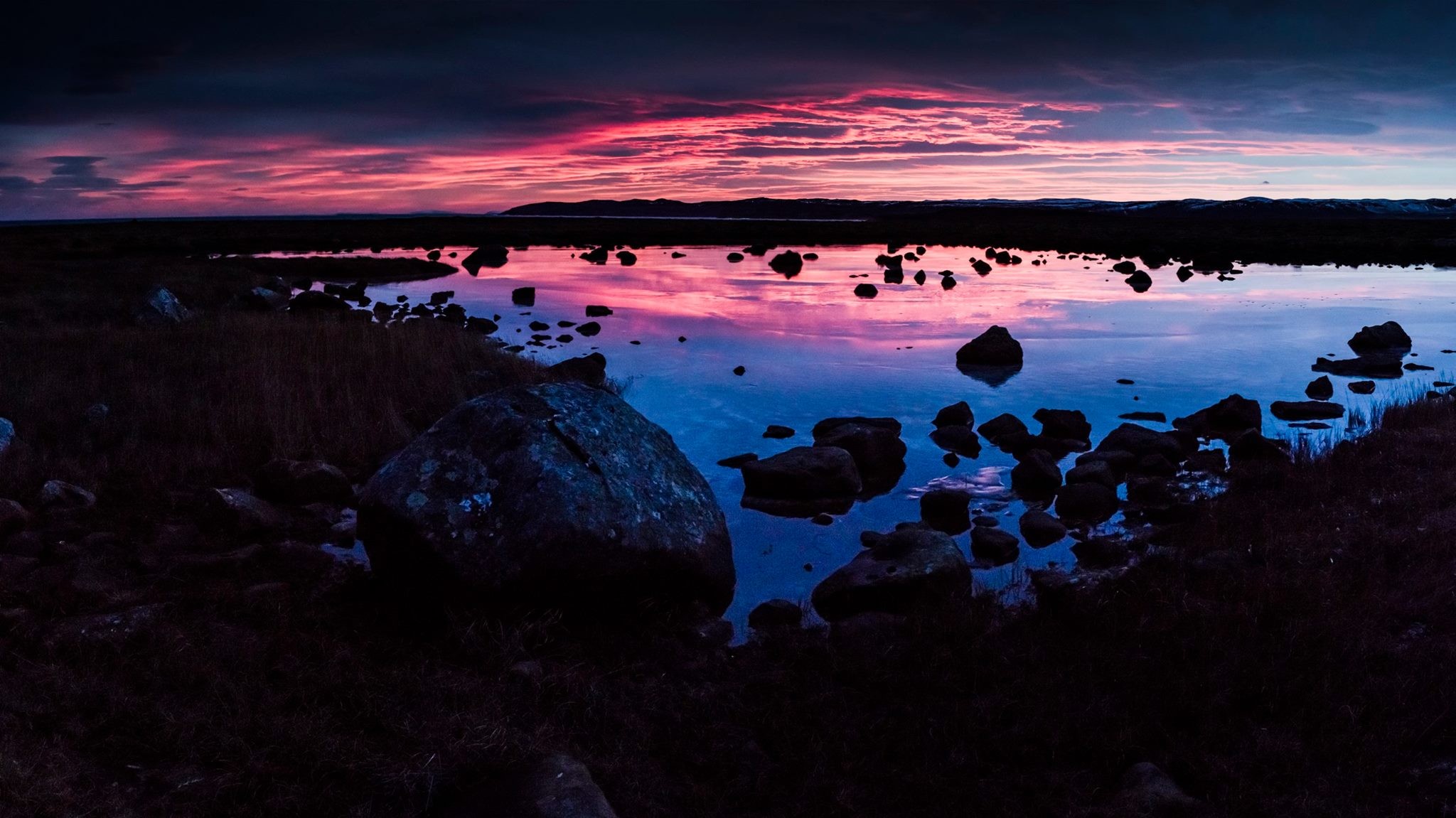 Sunset over a rocky landscape with a calm lake HD Wallpaper