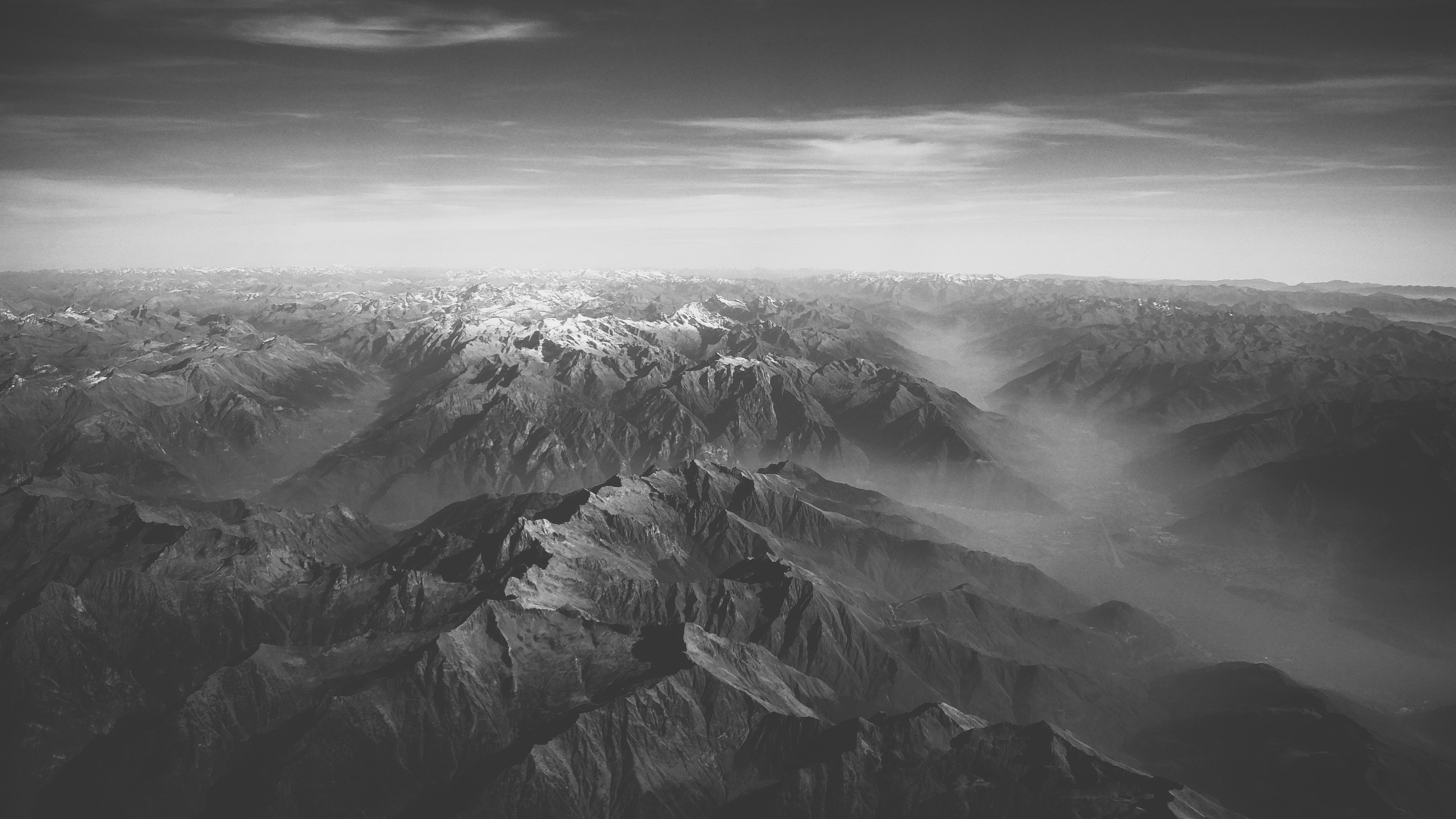 Aerial view of snow-capped mountains and valleys HD Wallpaper