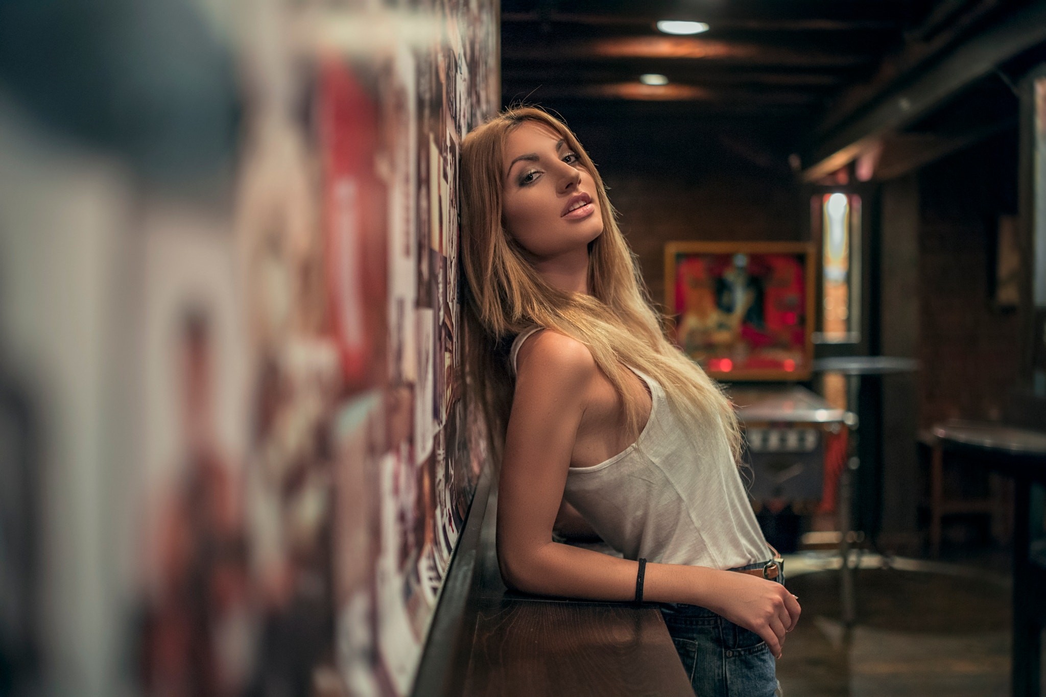 Woman leaning against a wall covered in photos HD Wallpaper