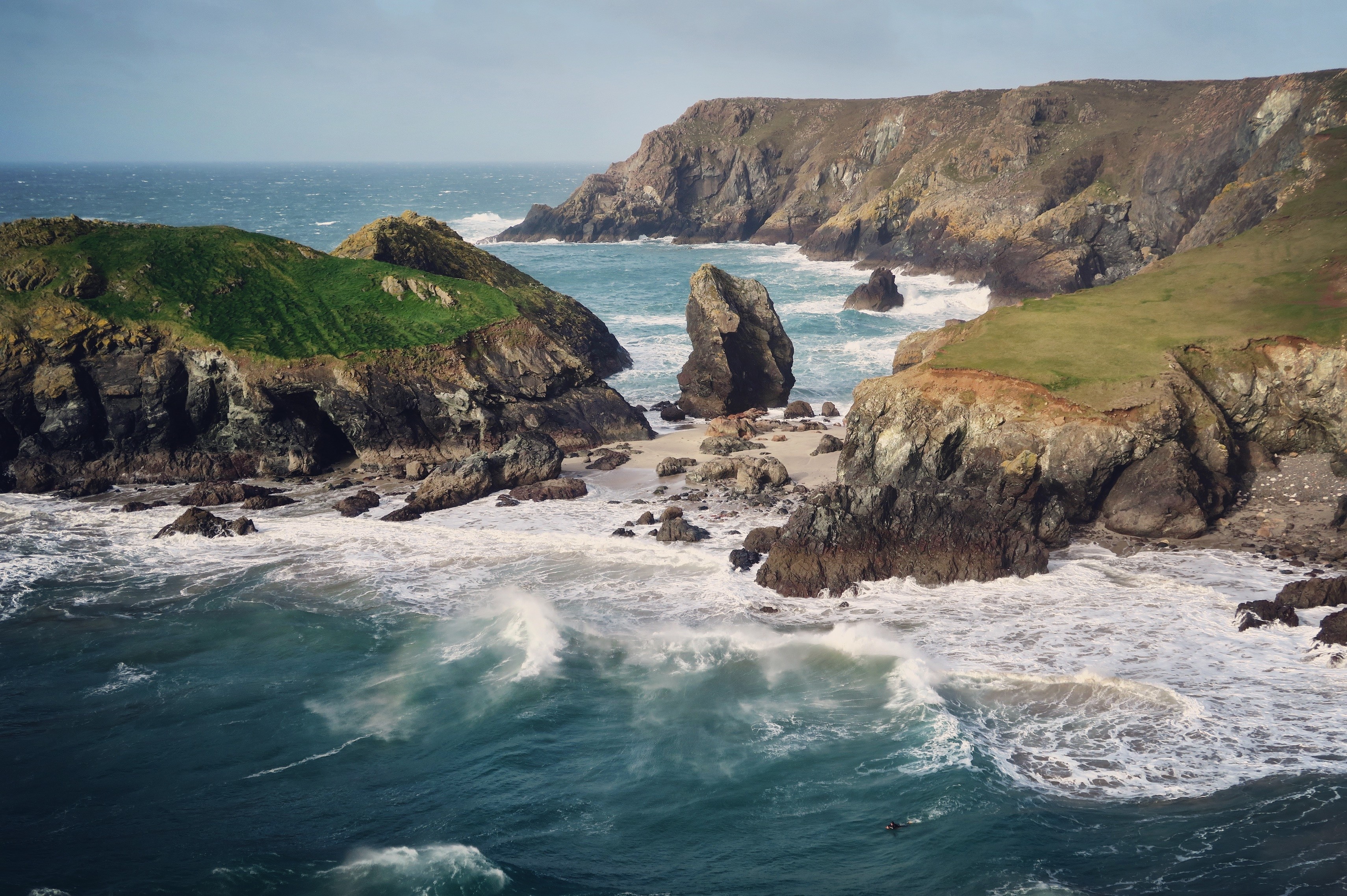 Rocky coastline with waves crashing on a beach HD Wallpaper