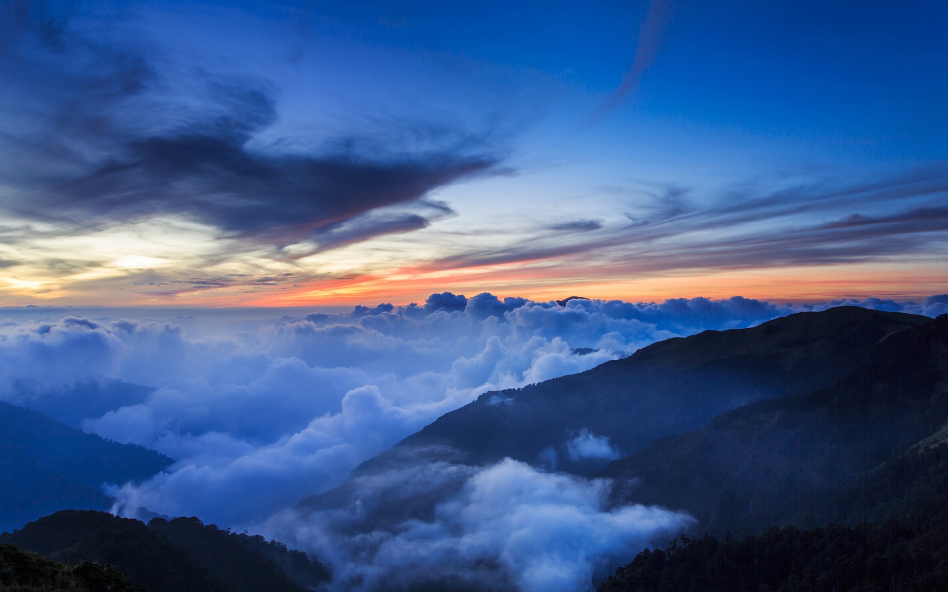 Mountains covered in clouds at sunset HD Wallpaper