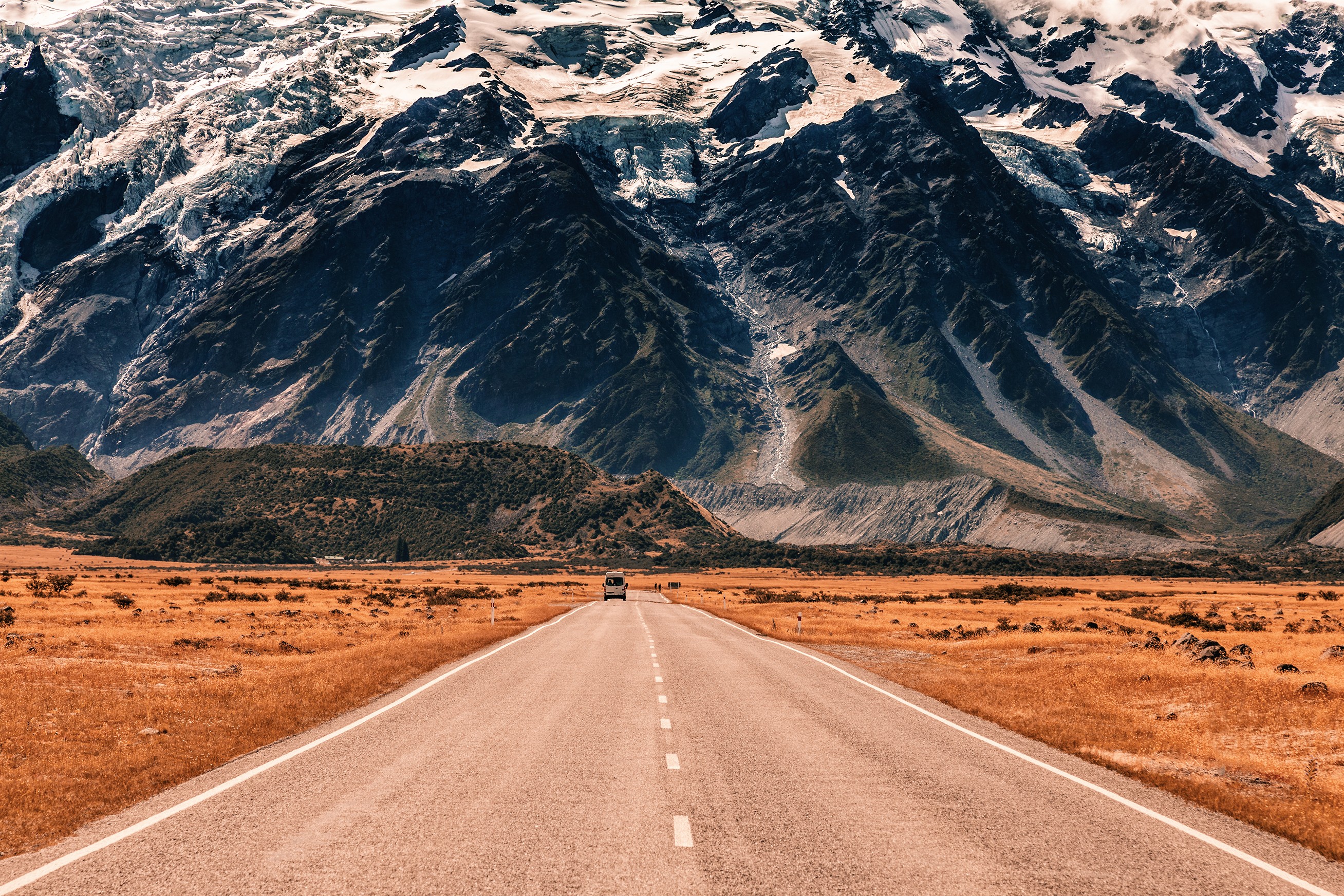 Road leading to snow-capped mountains HD Wallpaper