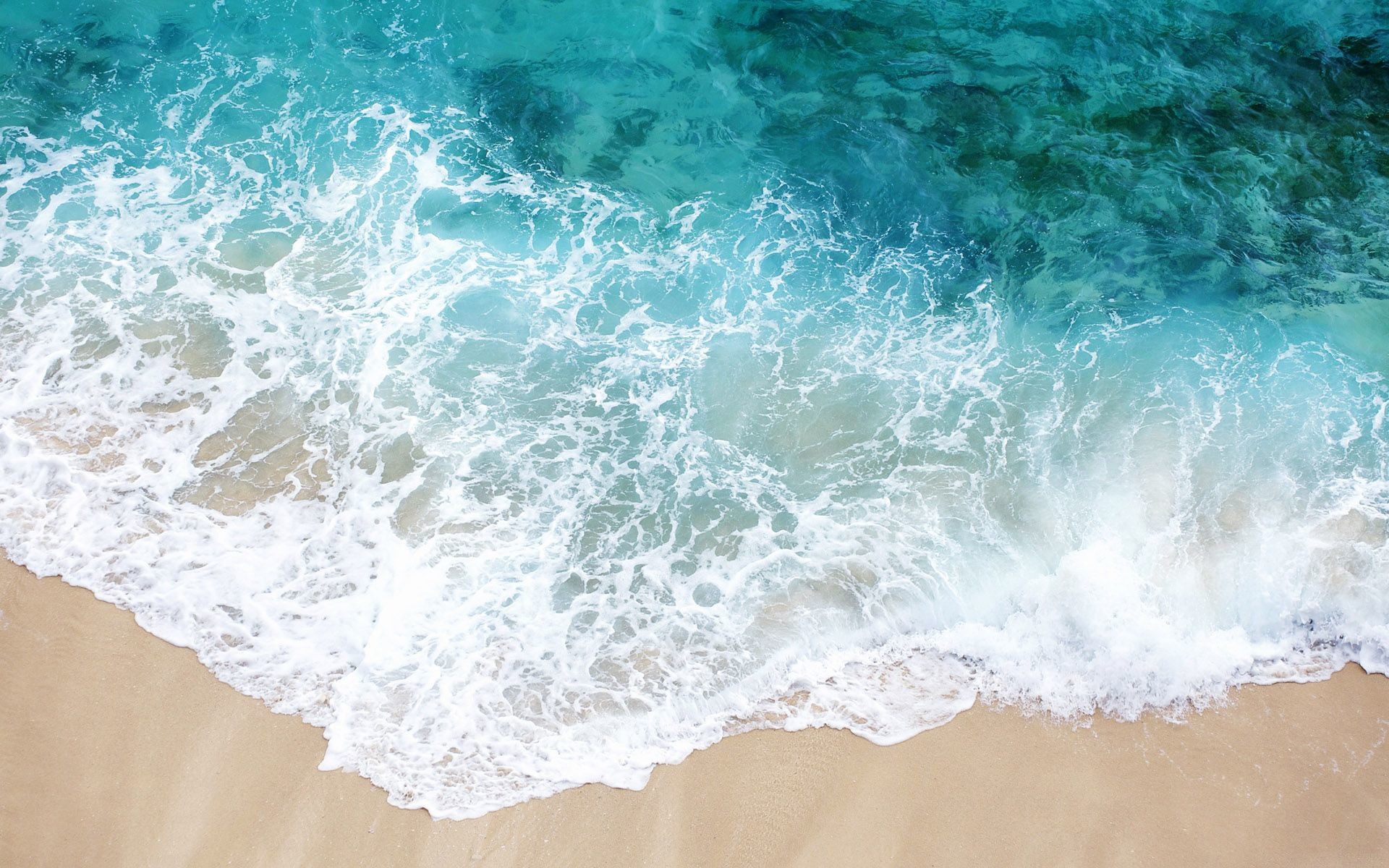 Ocean waves crashing on a sandy beach HD Wallpaper