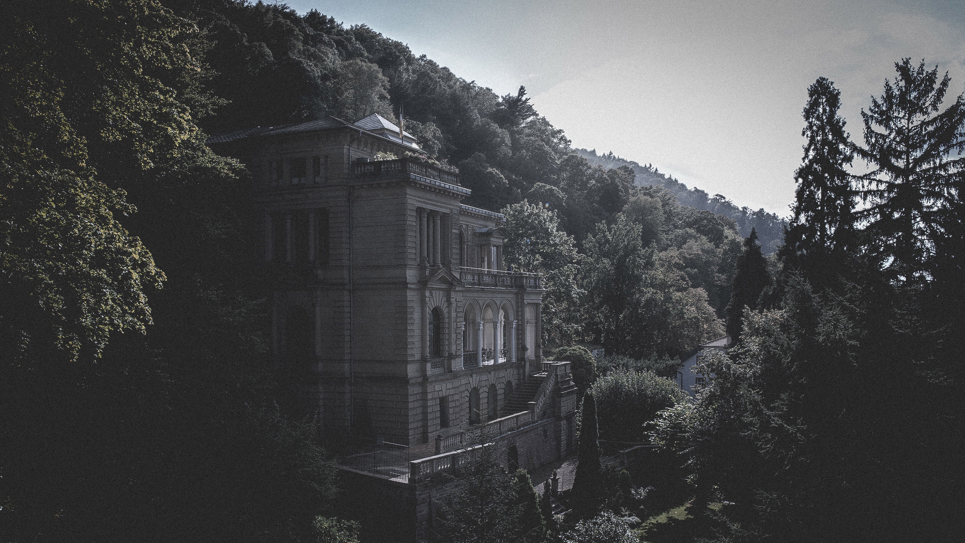 Stone mansion on a forested hillside HD Wallpaper
