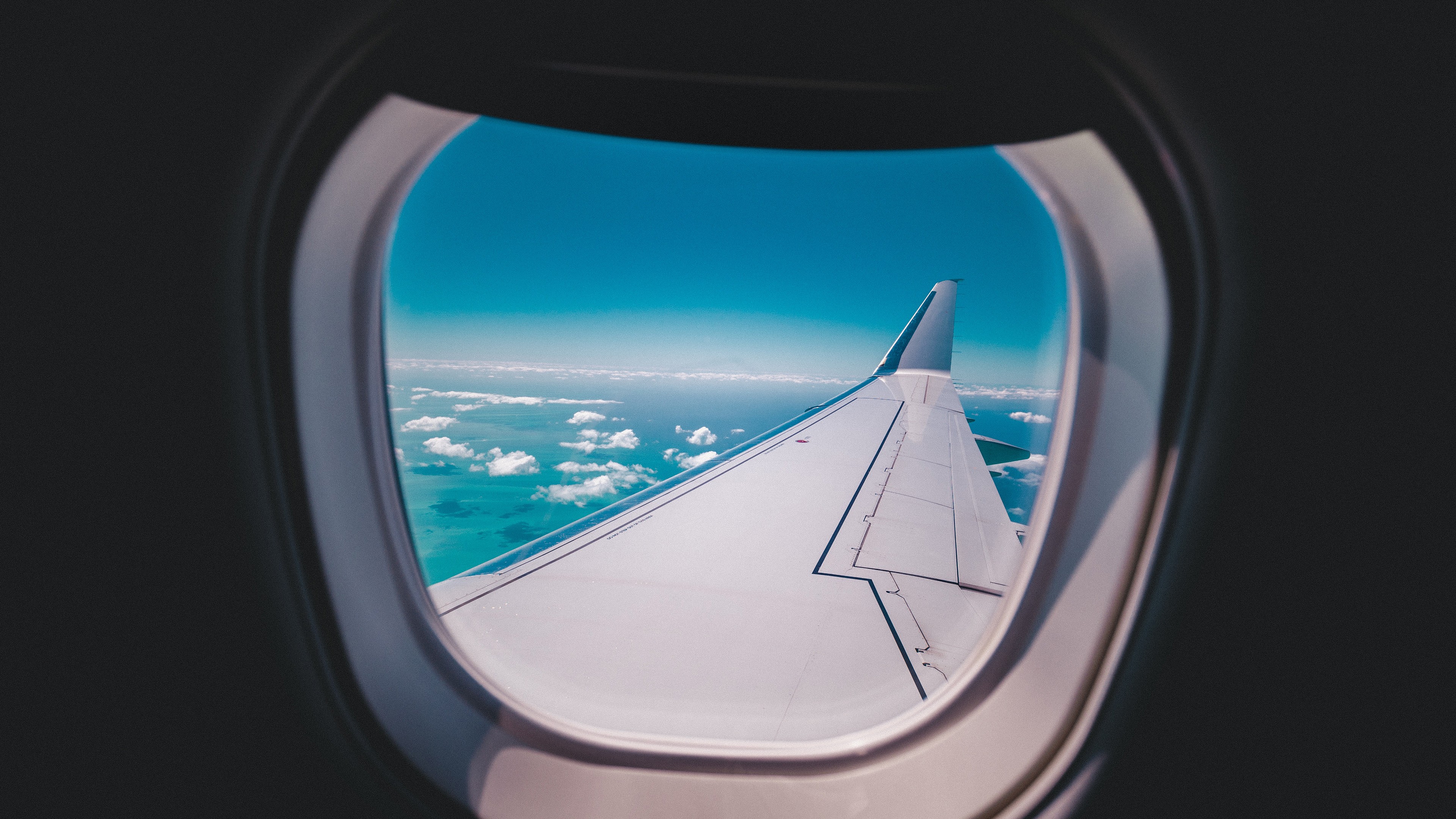 Airplane wing seen through a window HD Wallpaper