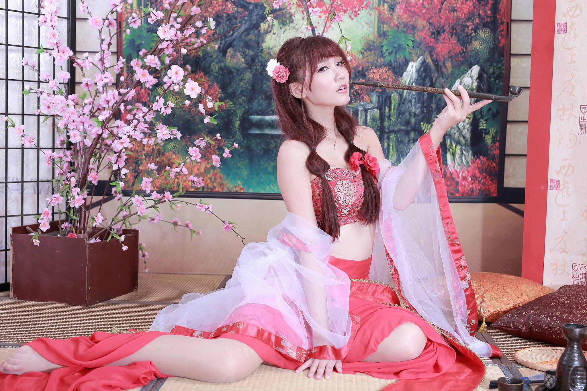 Asian woman in traditional red and white outfit holding a pipe HD Wallpaper