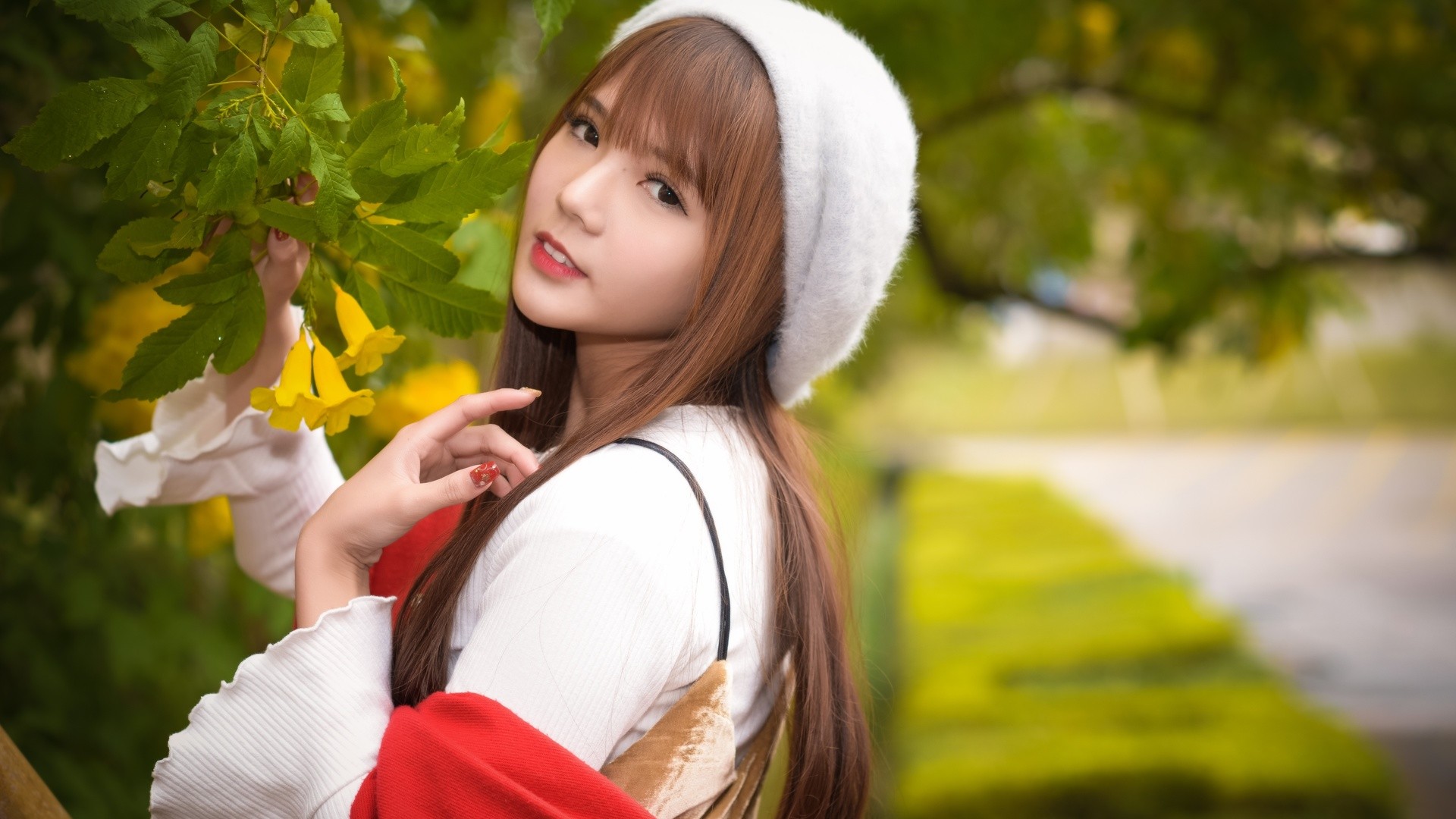 Young woman with bangs and a white hat outdoors HD Wallpaper