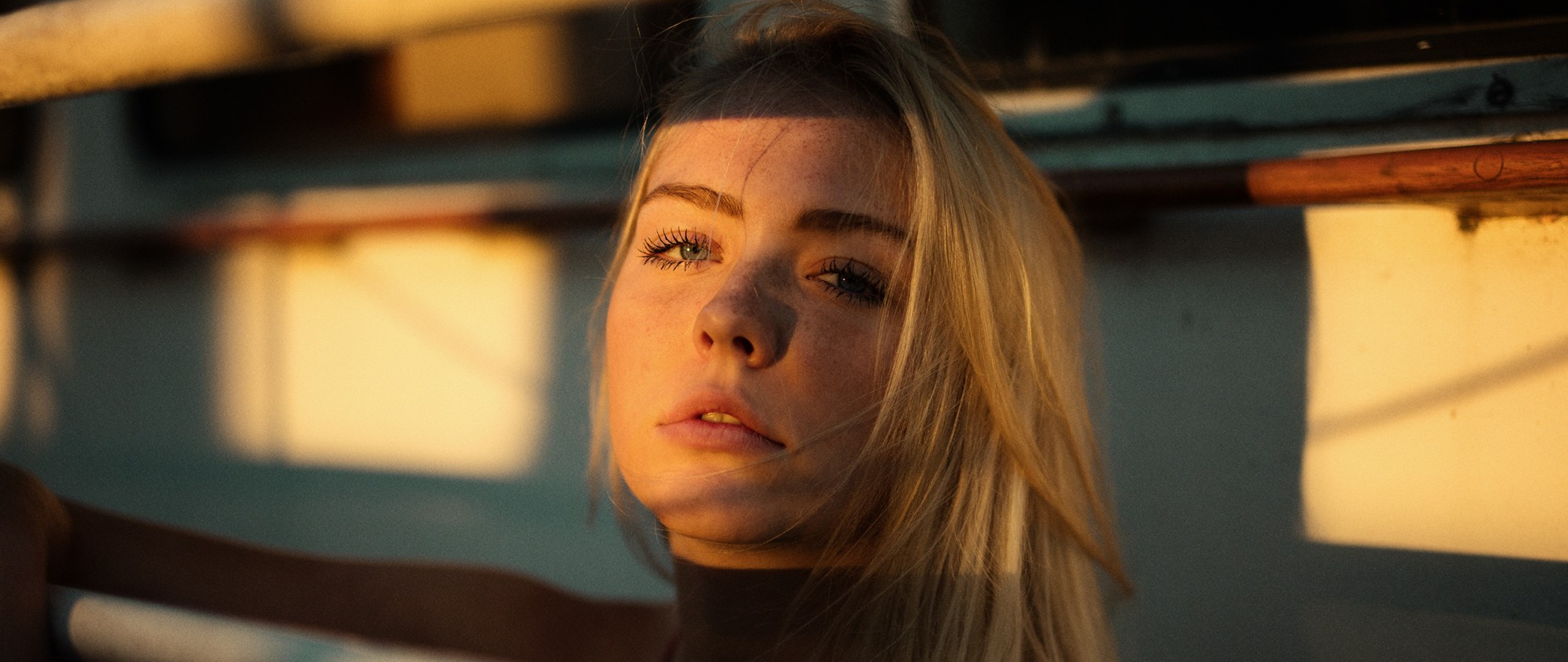 Woman with blonde hair and freckles in sunlight HD Wallpaper