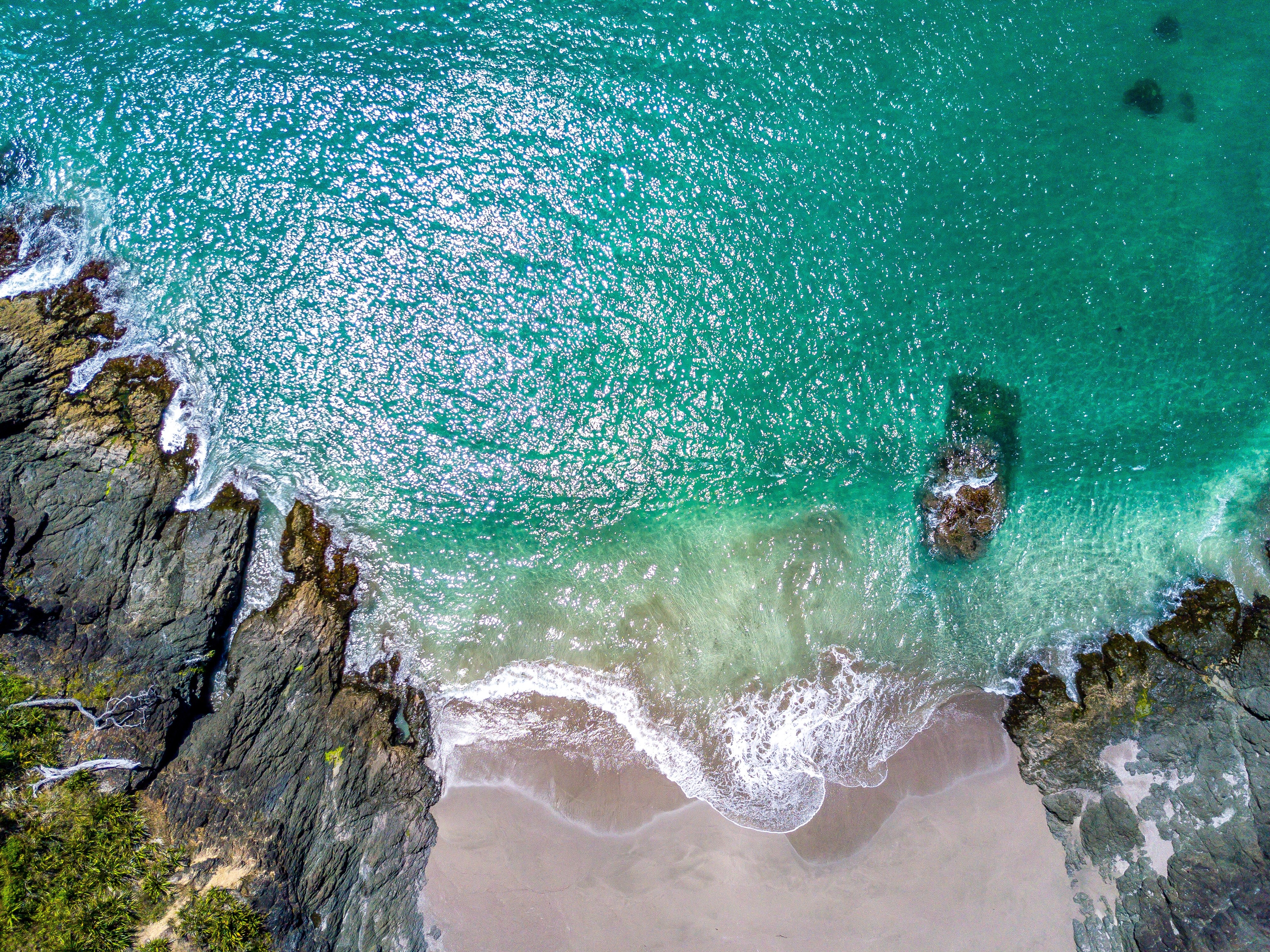 Aerial view of a rocky coastline and turquoise sea HD Wallpaper