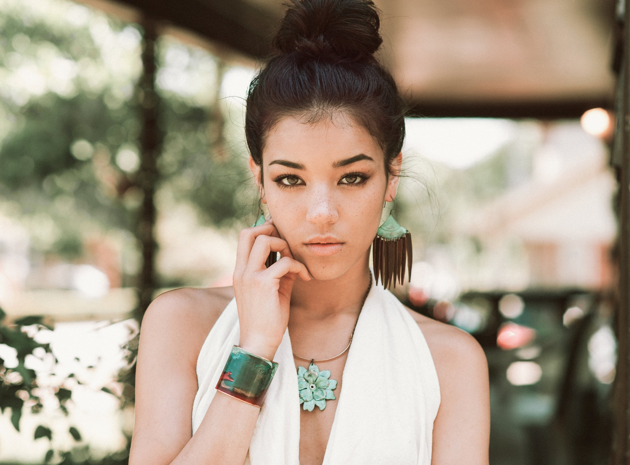 Woman with hair bun and jewelry outdoors HD Wallpaper