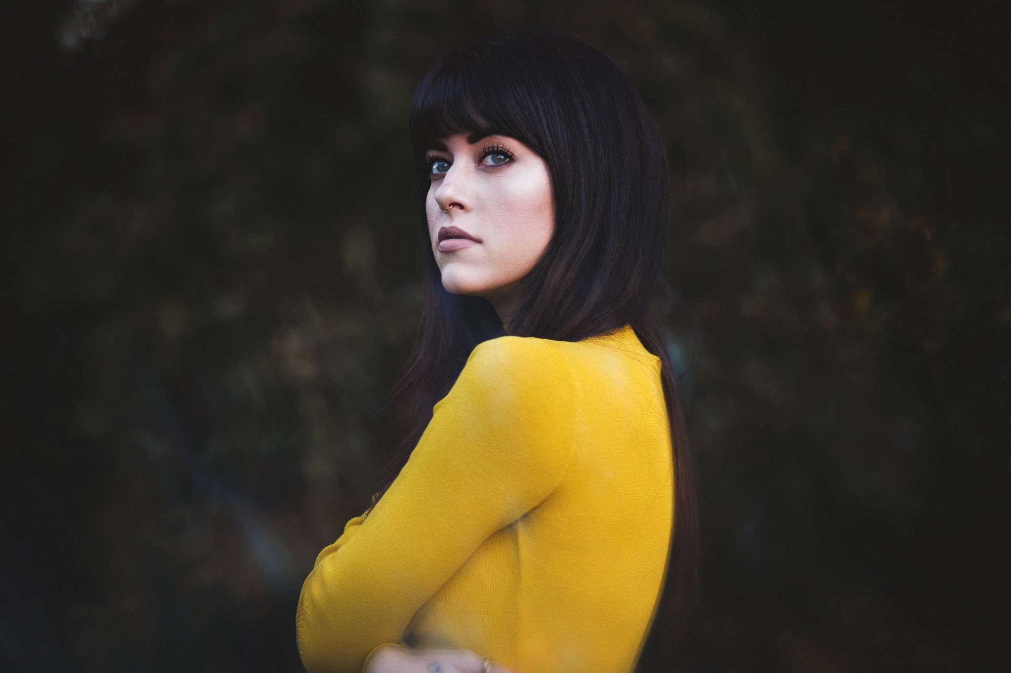 Woman in yellow sweater with dark hair and nose ring HD Wallpaper
