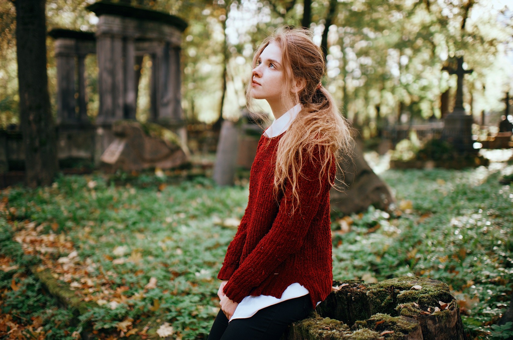 Woman with long blonde hair in a red sweater in a cemetery HD Wallpaper