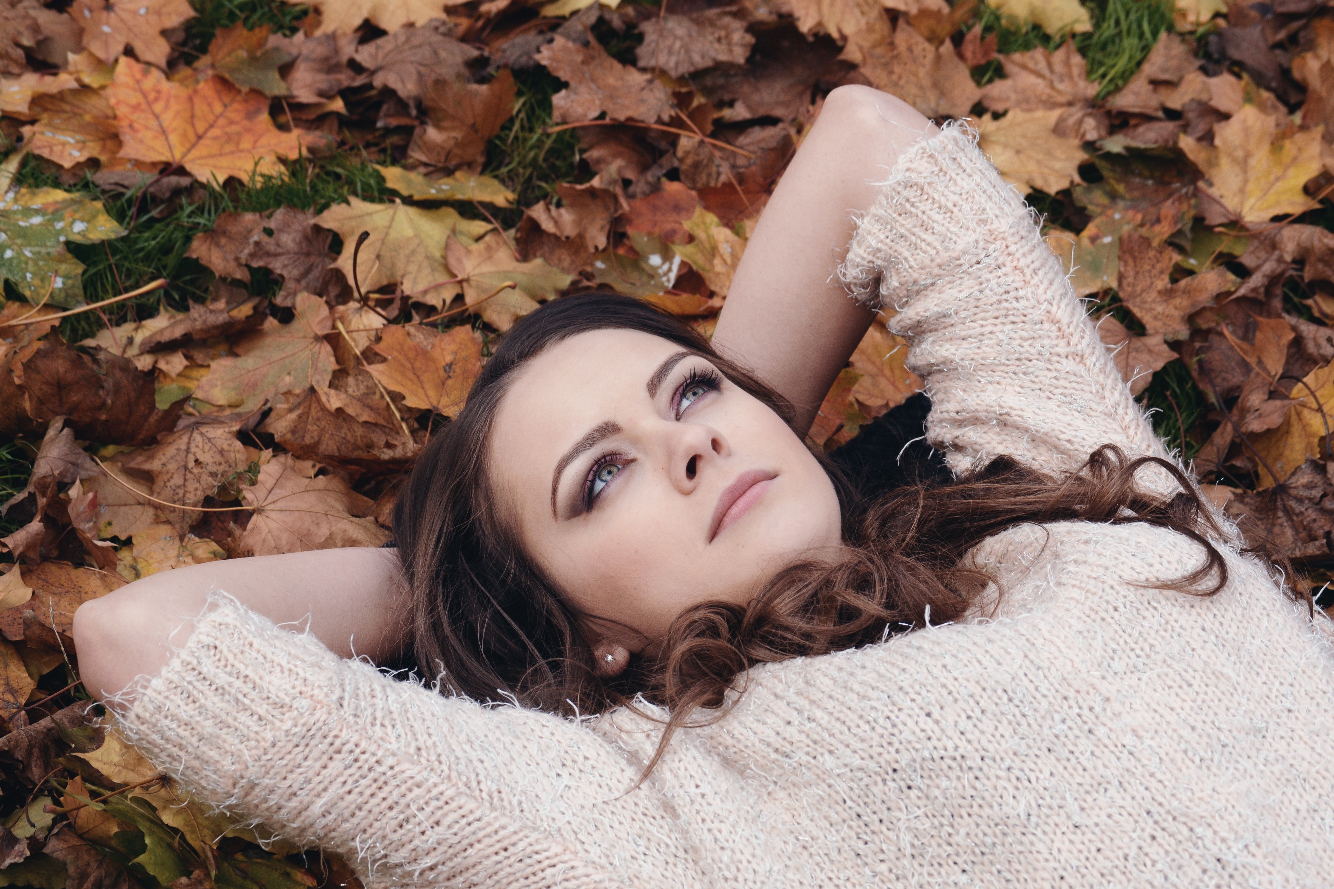 Woman lying on autumn leaves HD Wallpaper