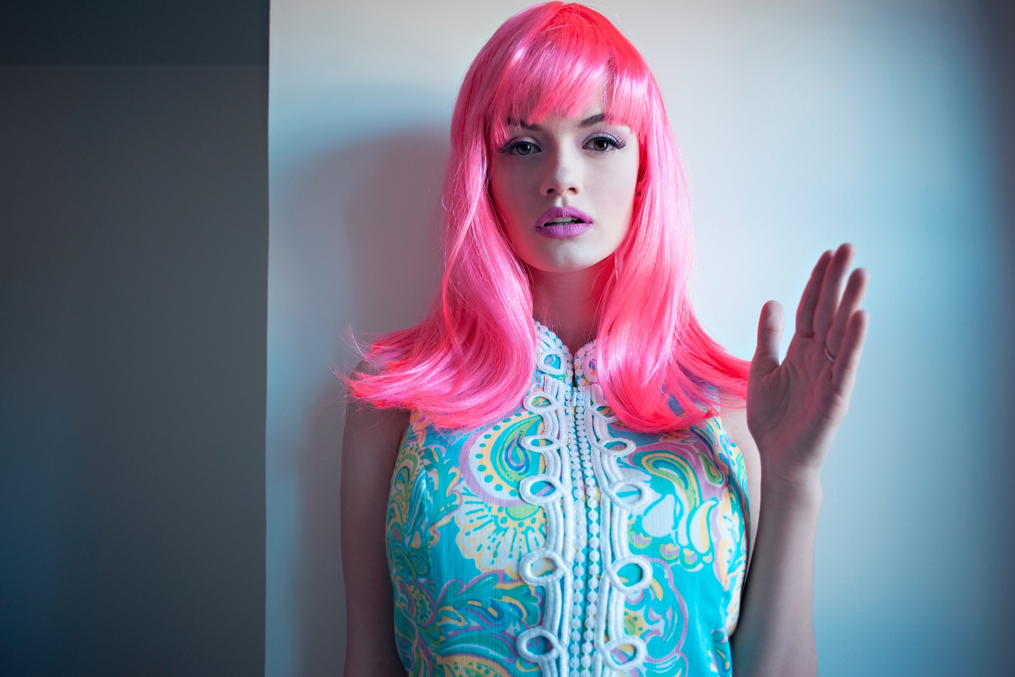 Woman with pink wig and patterned dress waving HD Wallpaper