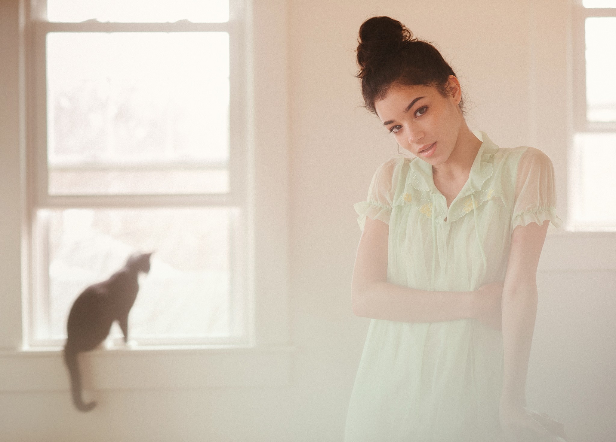 Woman with hairbun and black cat by window HD Wallpaper
