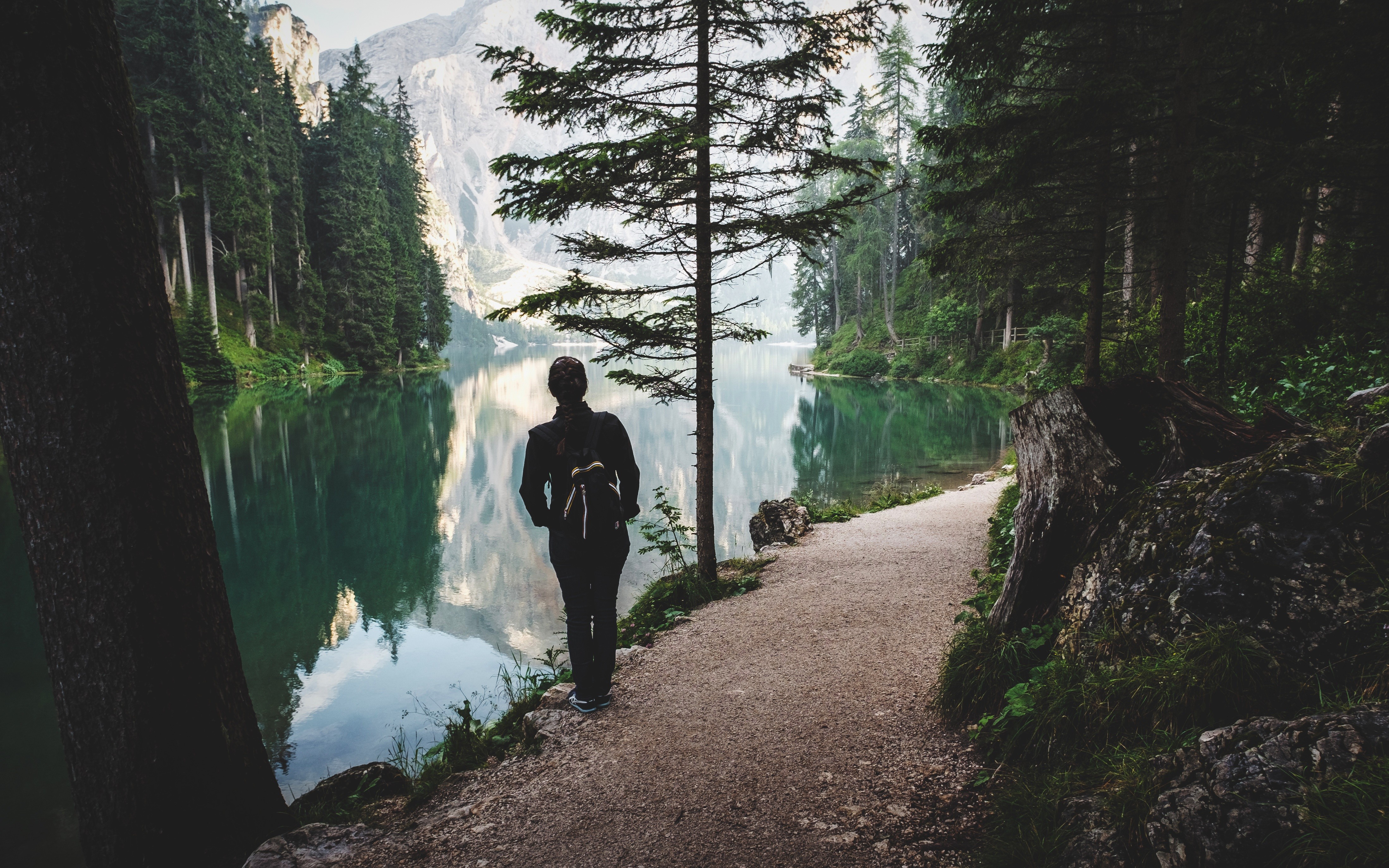 Woman with backpack by a lake in the mountains HD Wallpaper