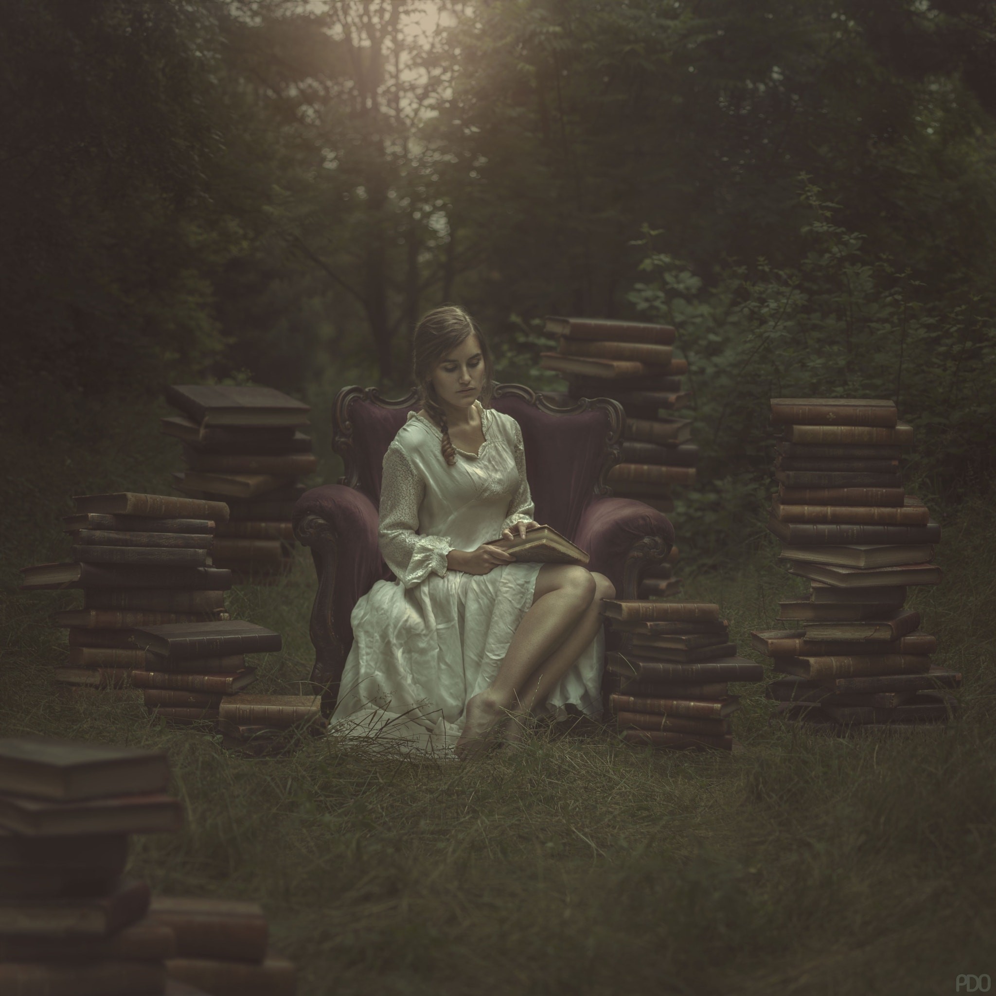 Woman reading a book in a forest surrounded by books HD Wallpaper