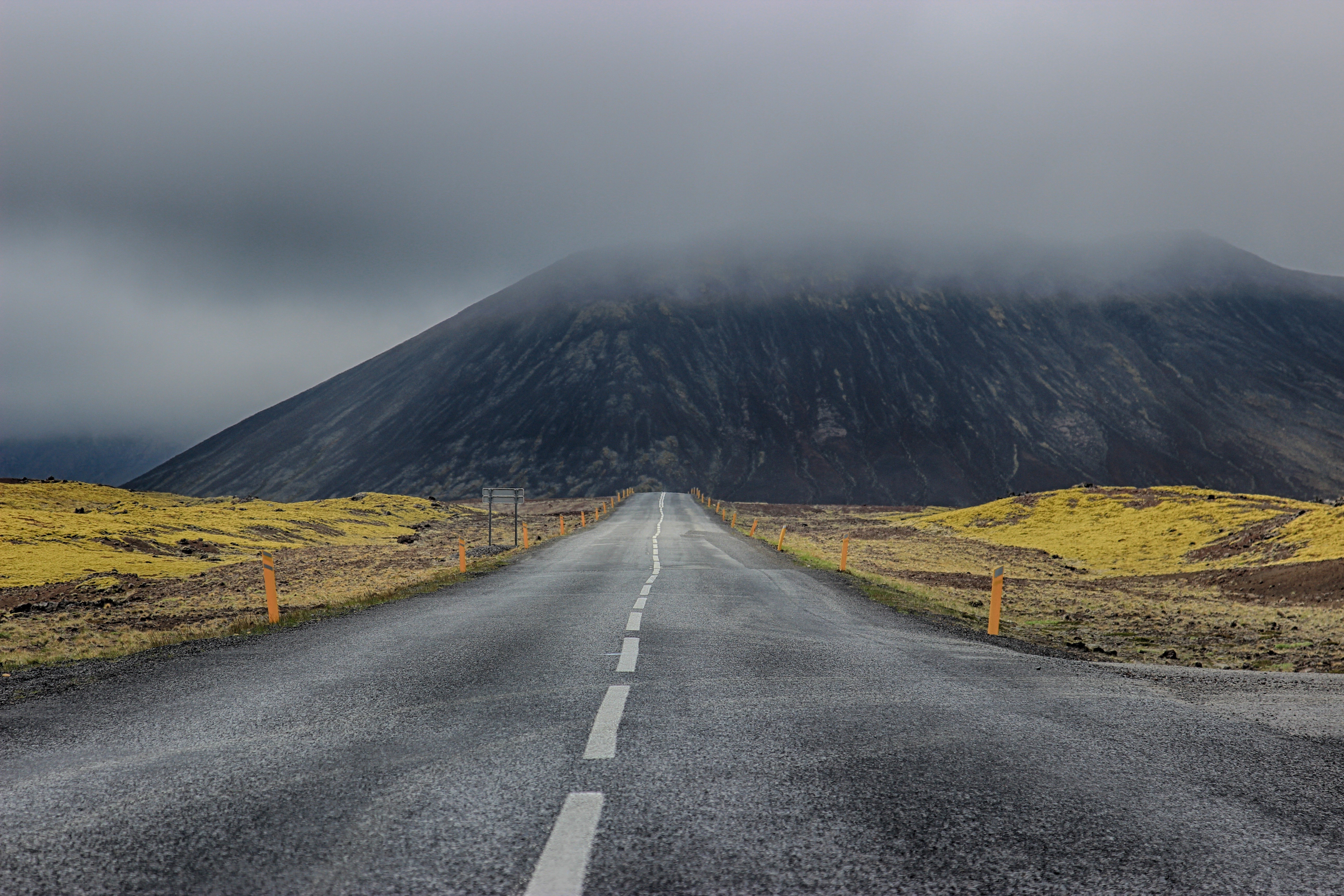 Empty road leading to a misty mountain HD Wallpaper