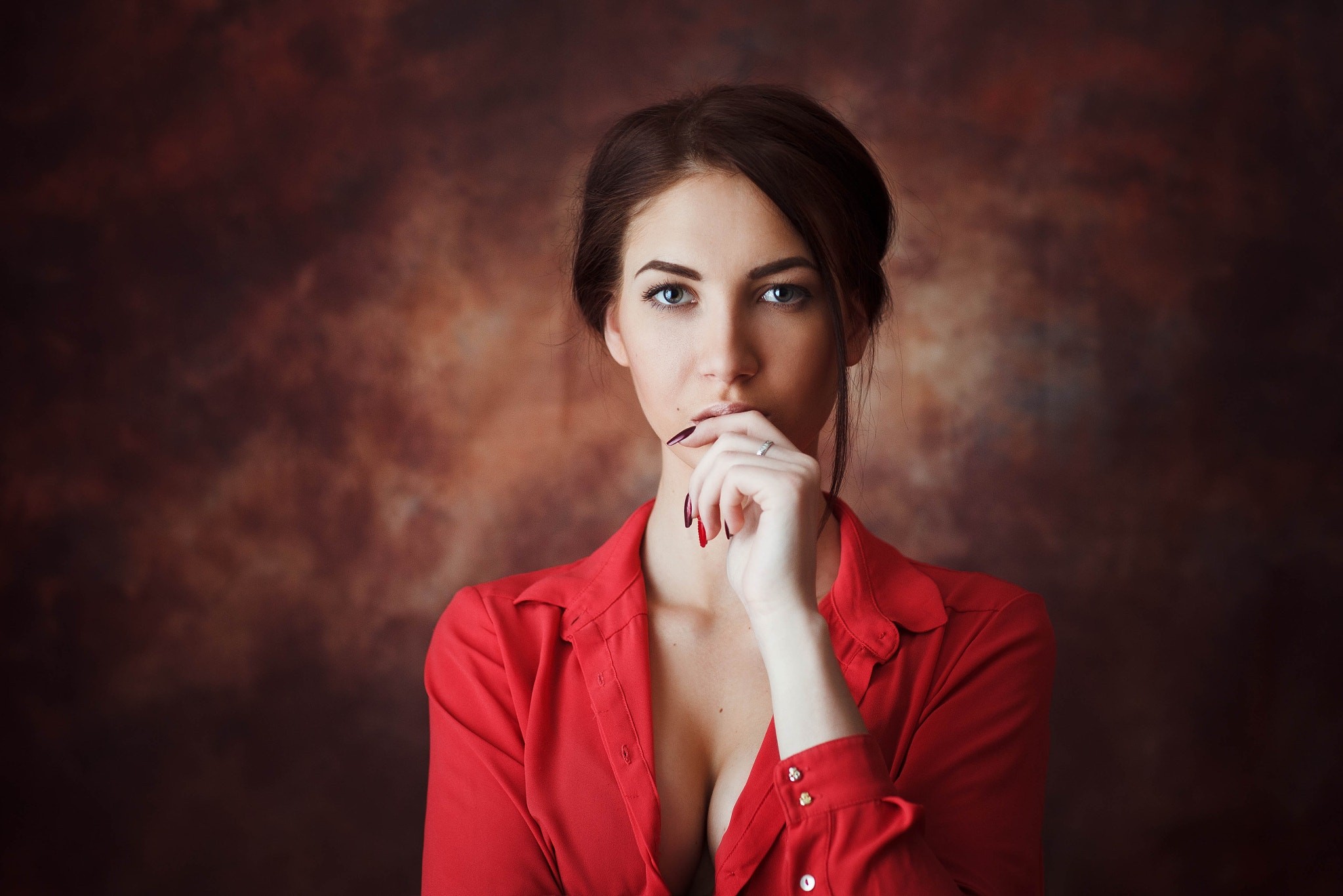 Woman in red shirt with hand on chin HD Wallpaper