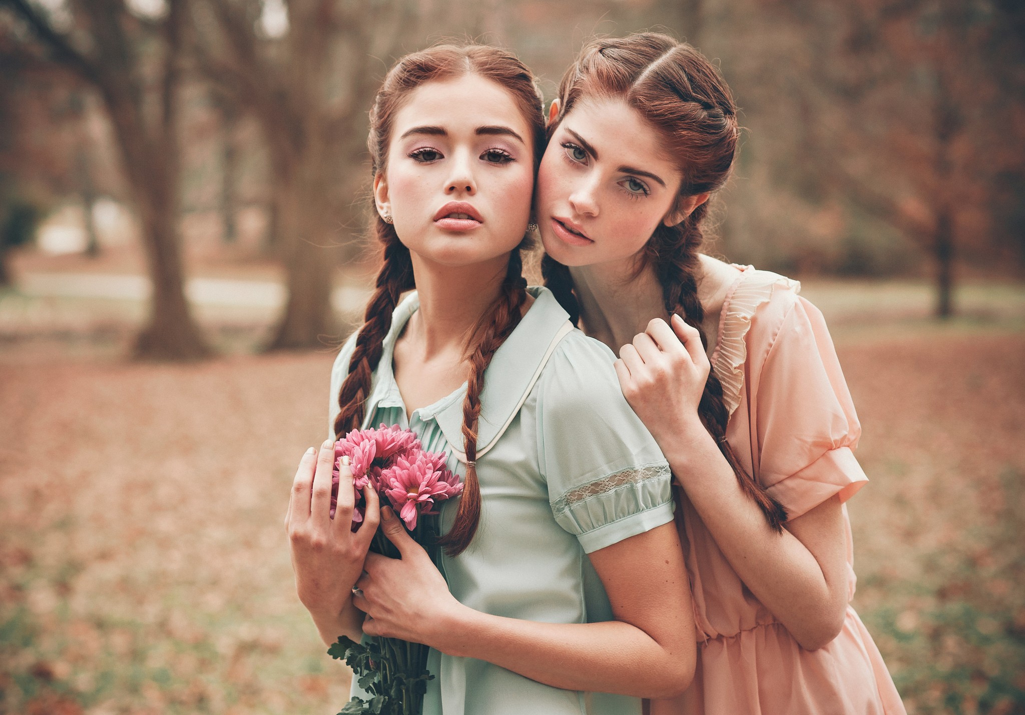 Two young women with braids holding flowers HD Wallpaper