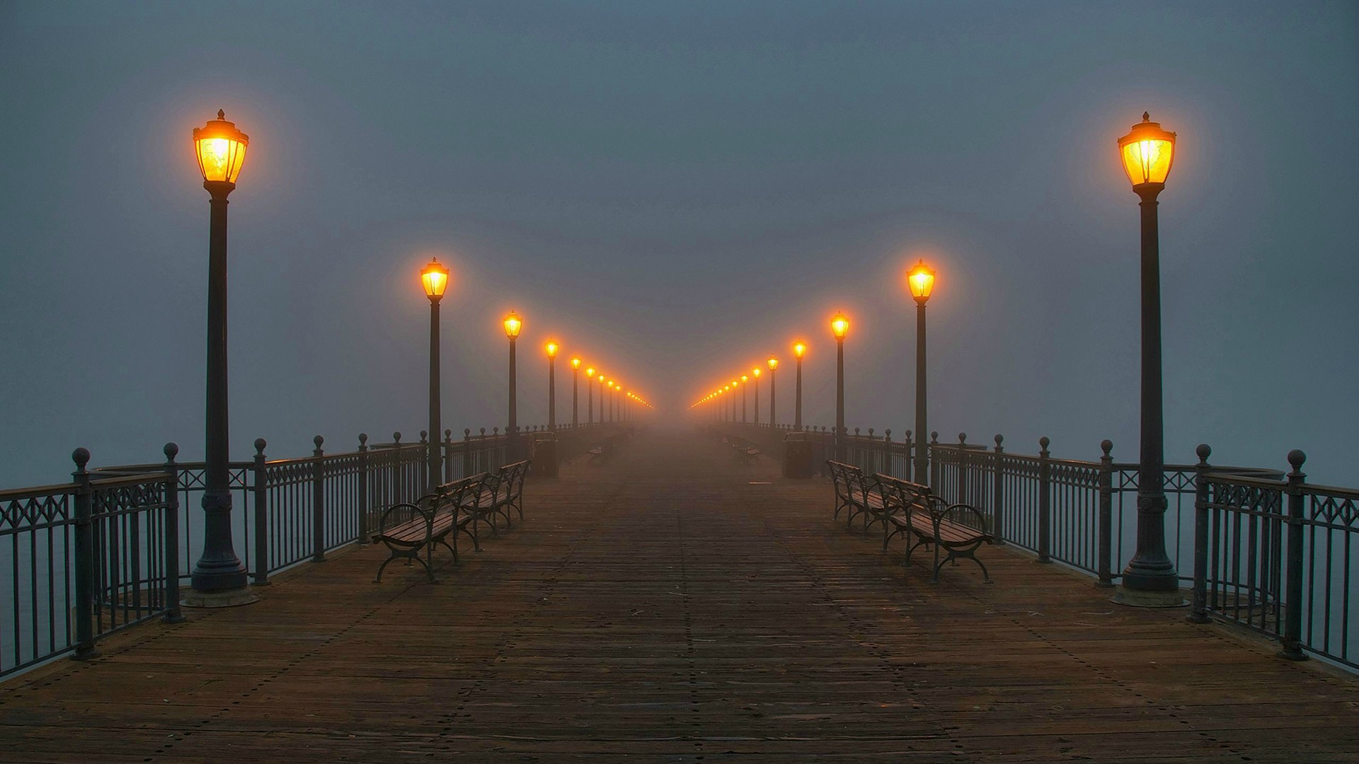 Pier with gas lamps and benches in fog HD Wallpaper