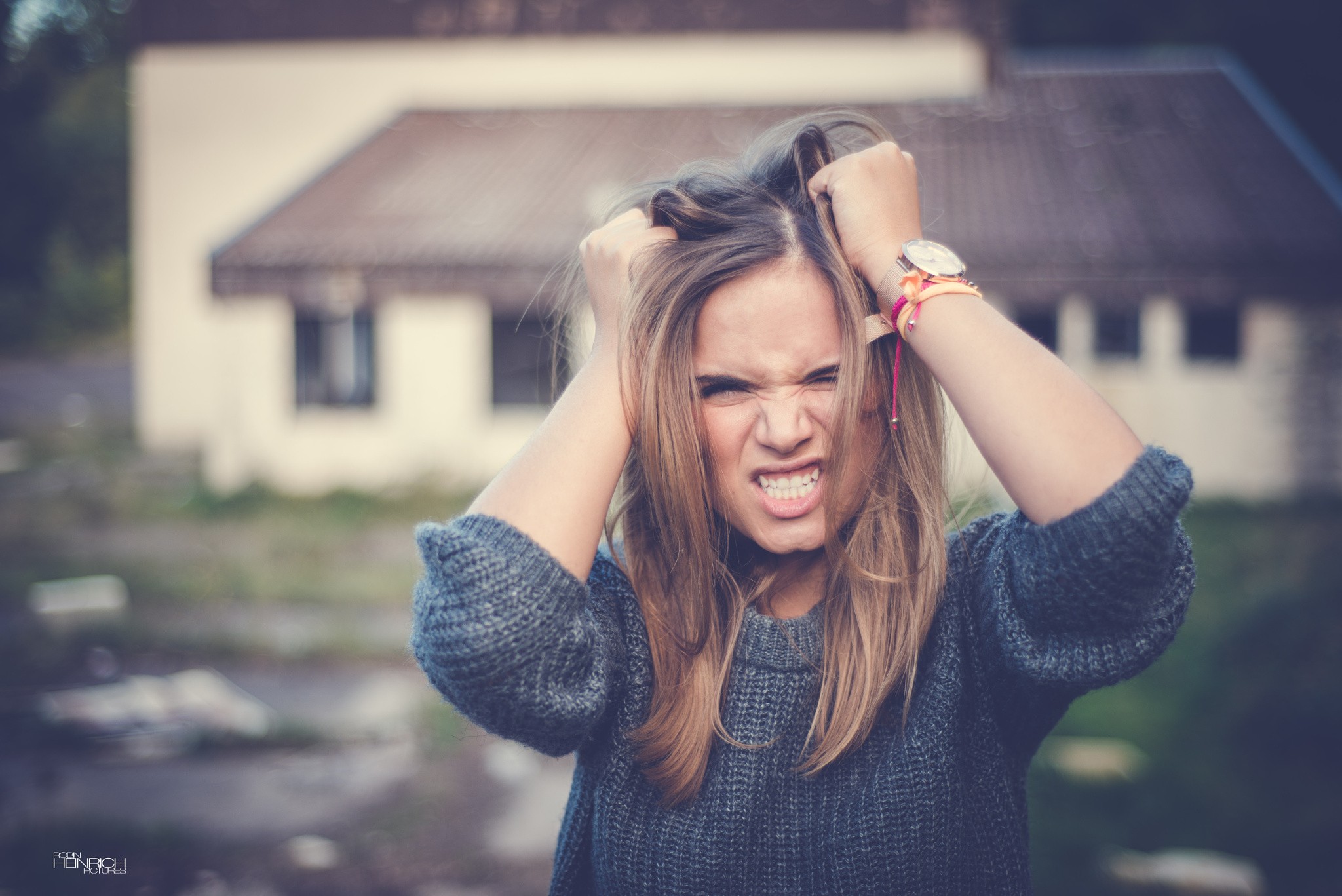 Woman with hands in hair, angry expression HD Wallpaper