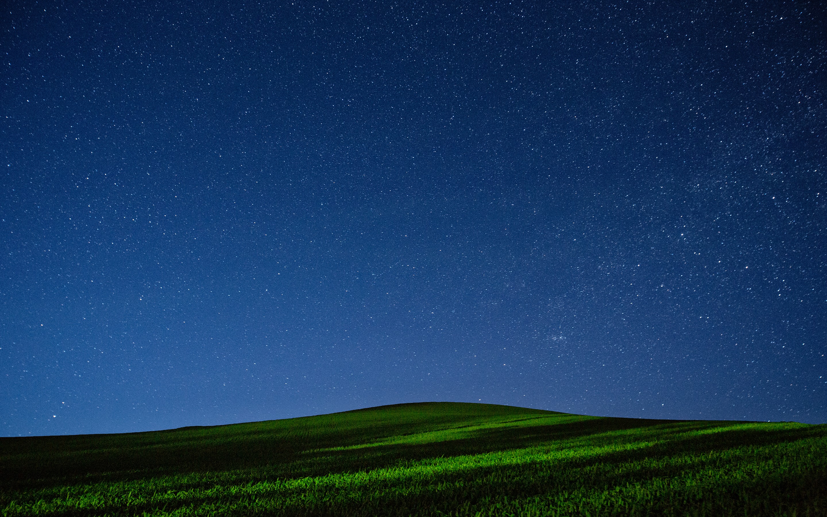 Starry night sky over a green hill HD Wallpaper