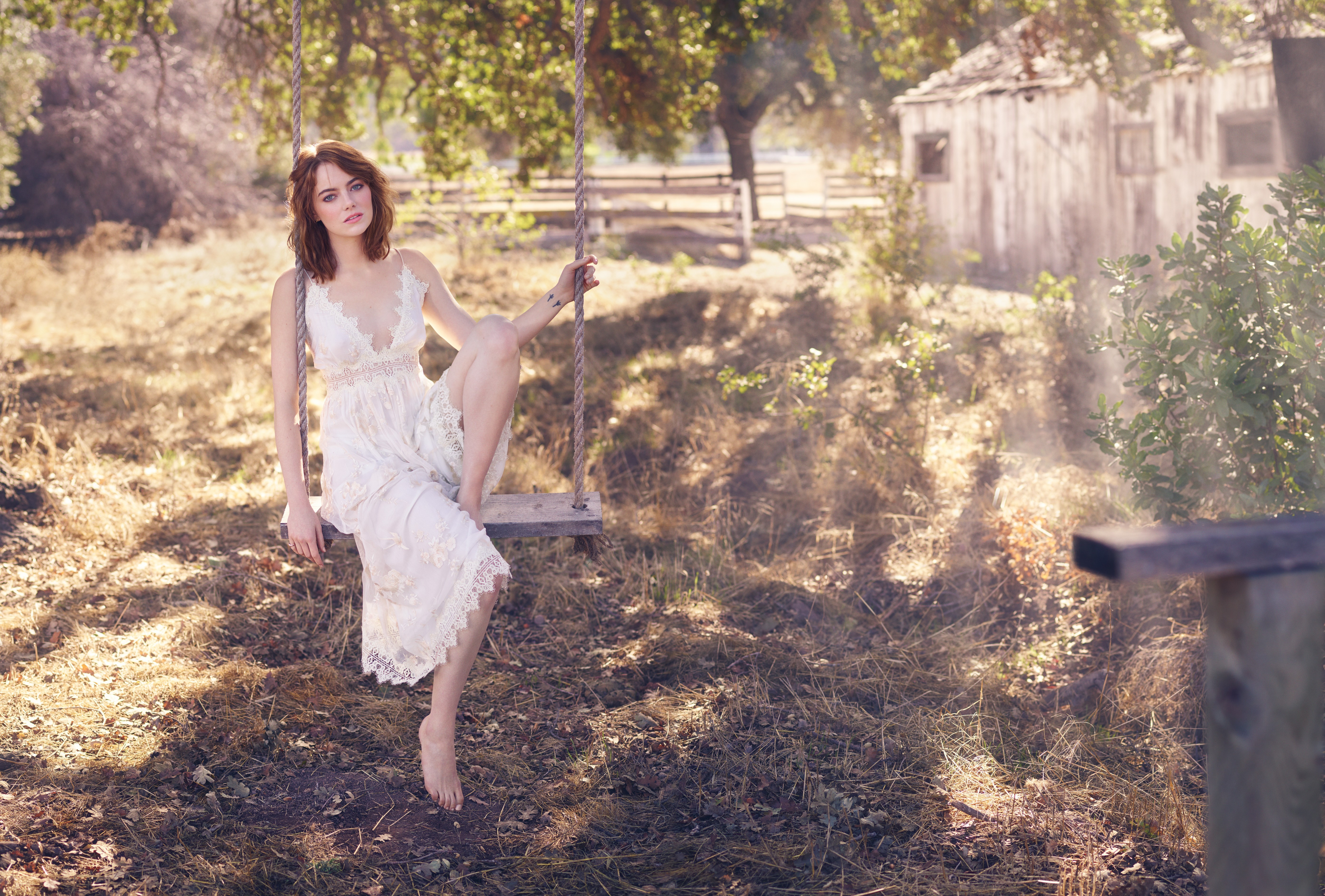 Emma Stone on a swing outdoors HD Wallpaper