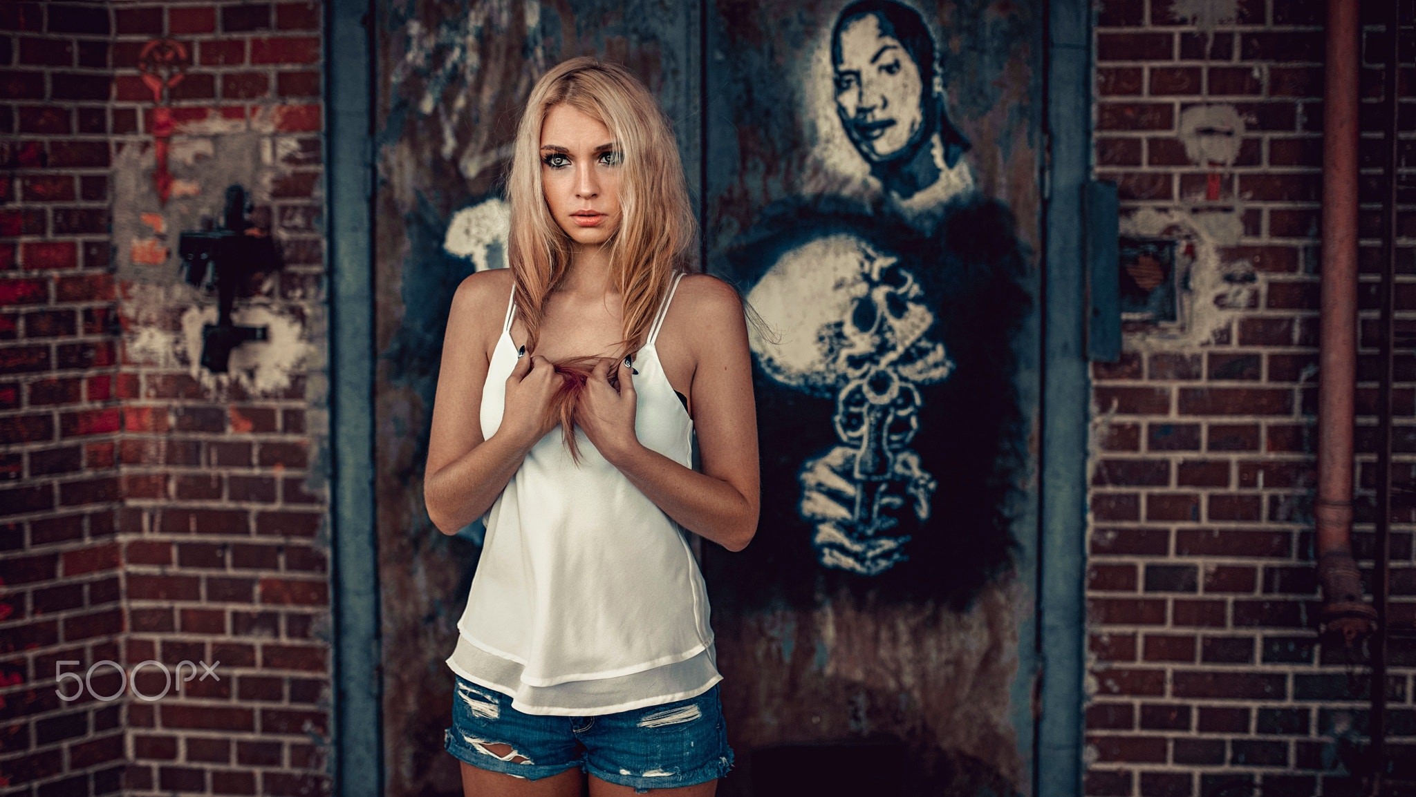 Woman in jean shorts standing in front of graffiti HD Wallpaper