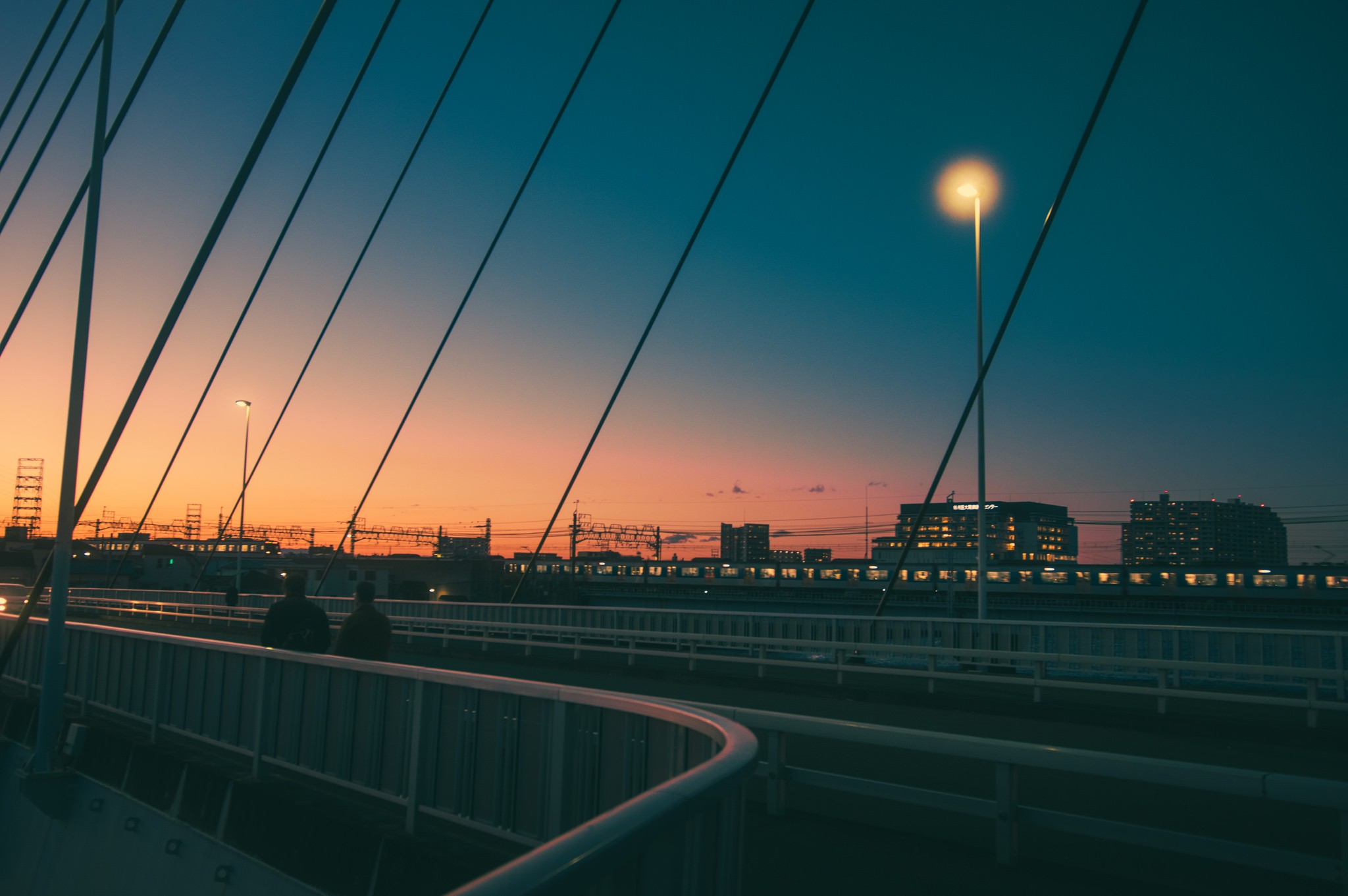 Cityscape at sunset with bridge and train HD Wallpaper