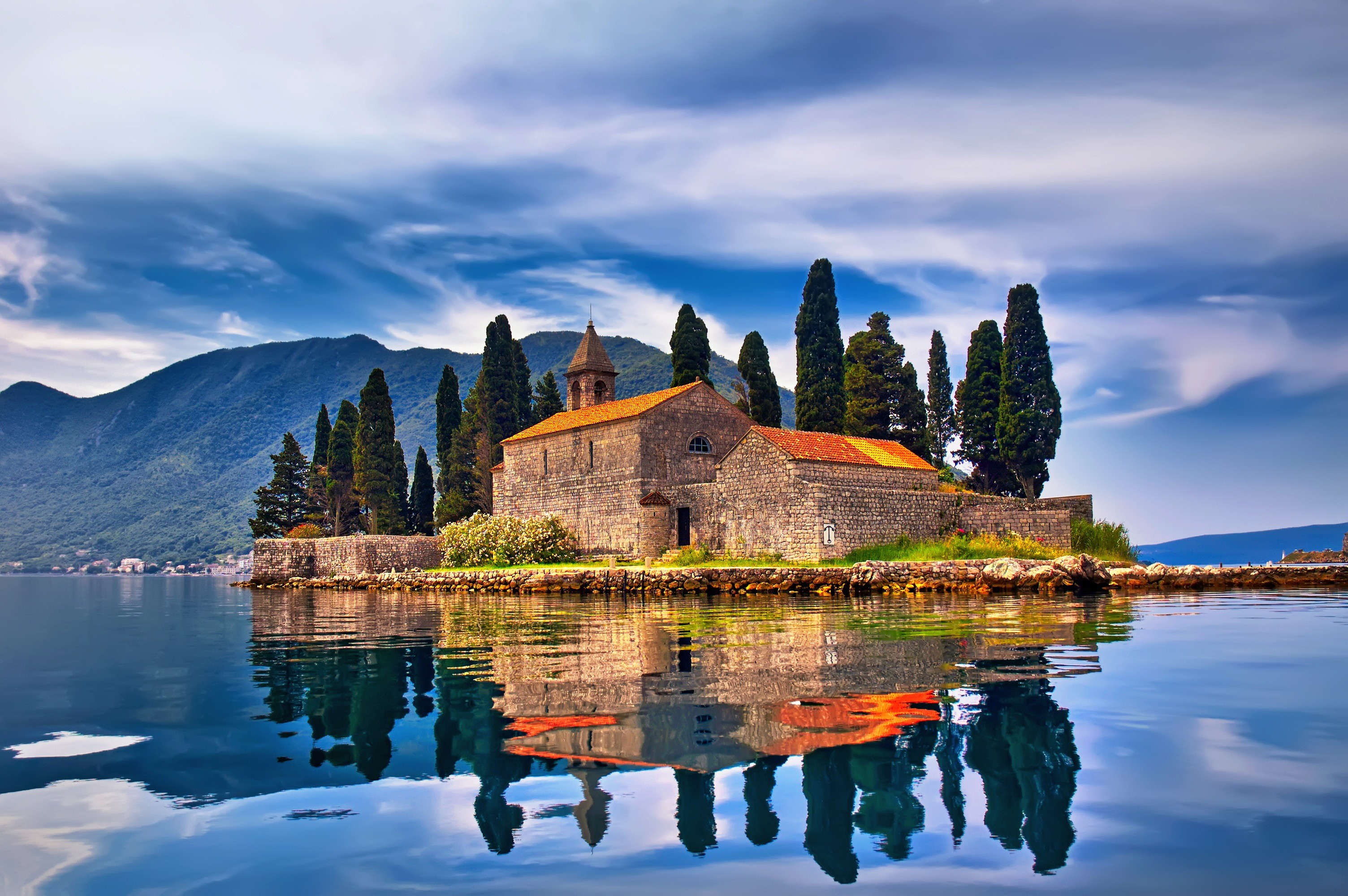 Island church with cypress trees and reflection in water HD Wallpaper