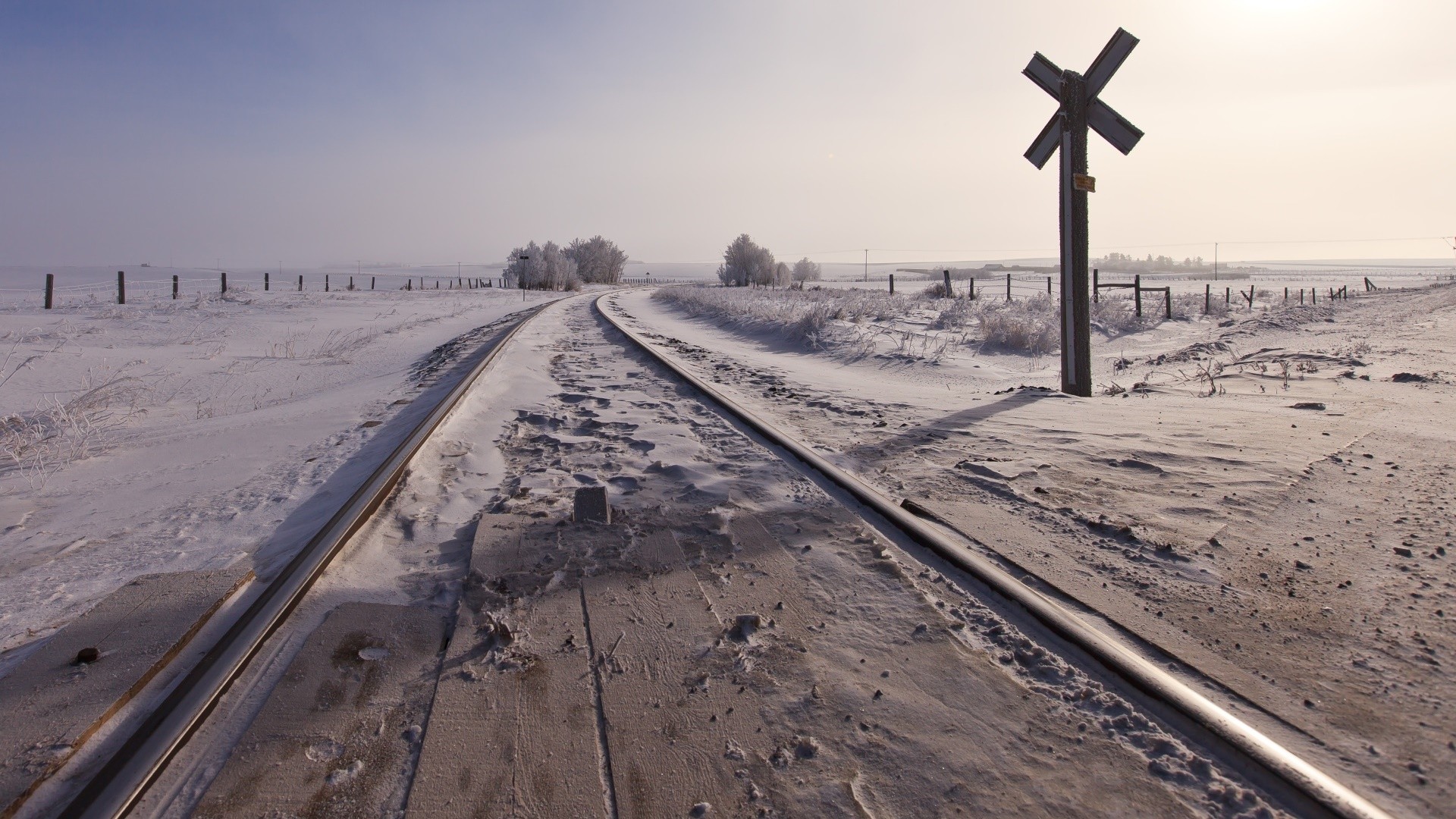 Snow-covered railway tracks in a winter landscape HD Wallpaper