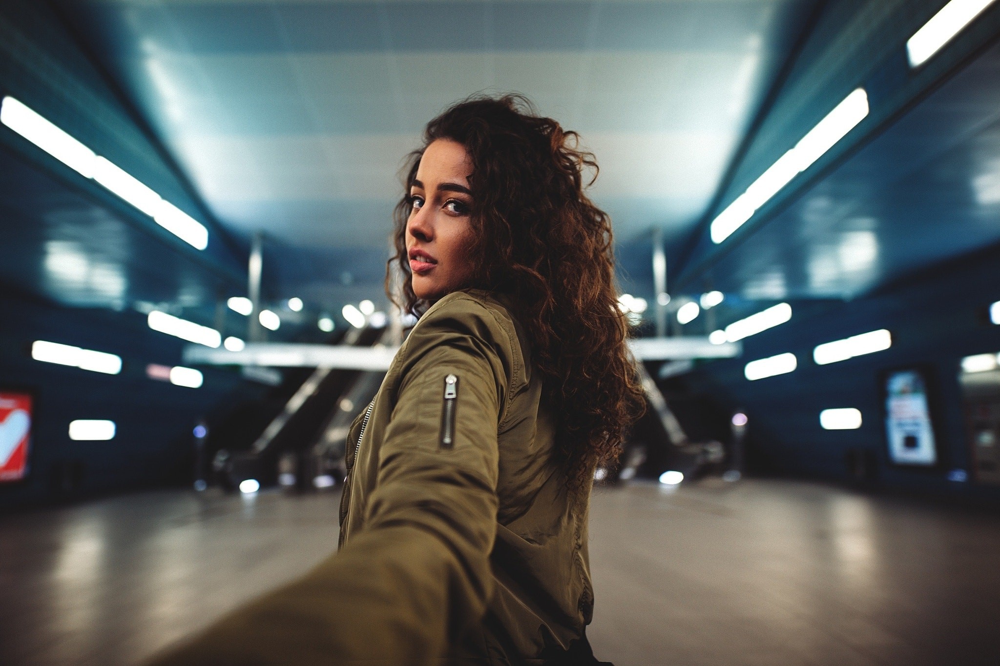 Woman with curly hair in a subway station HD Wallpaper