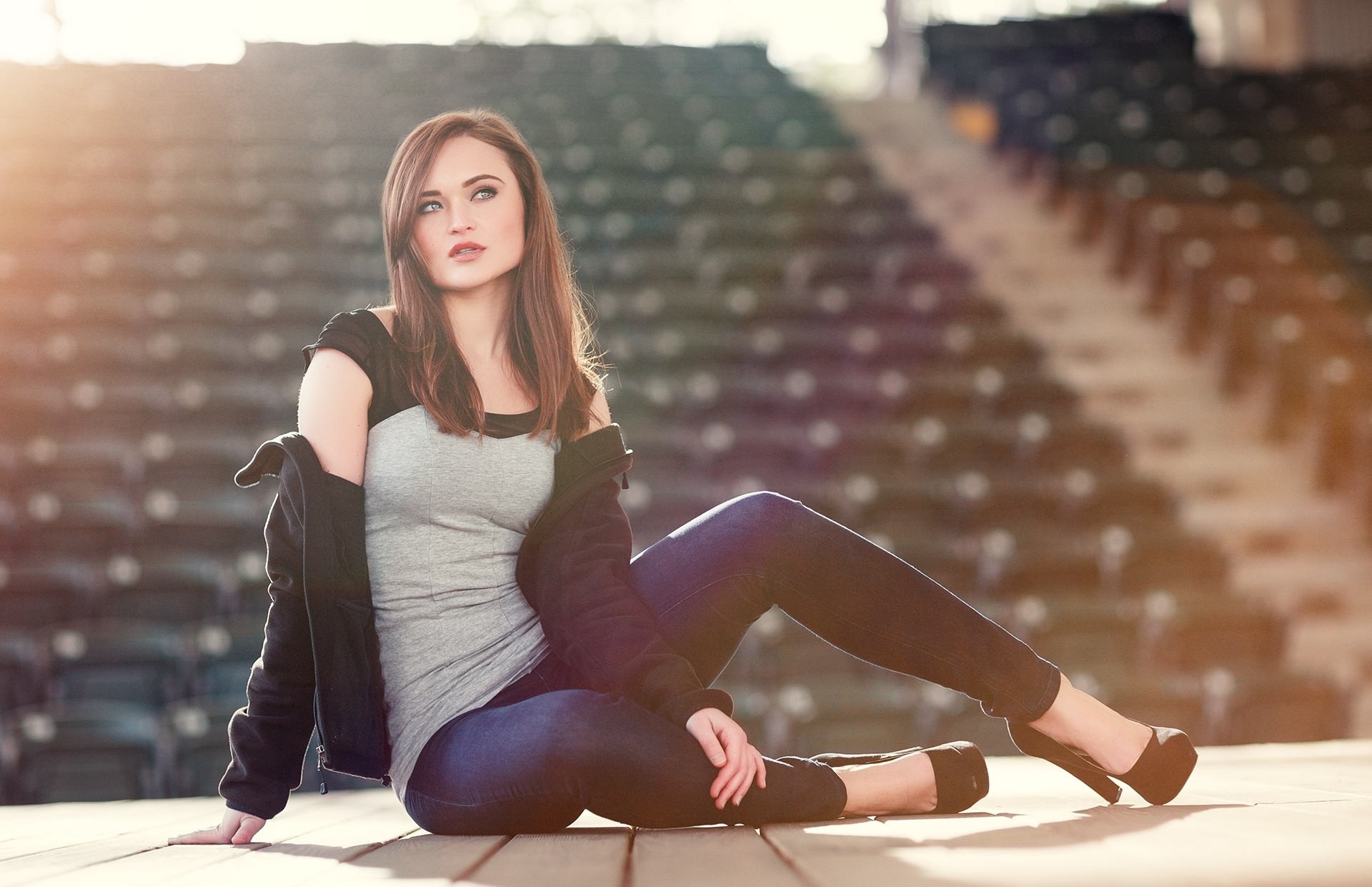 Woman in jeans and heels sitting on stage HD Wallpaper