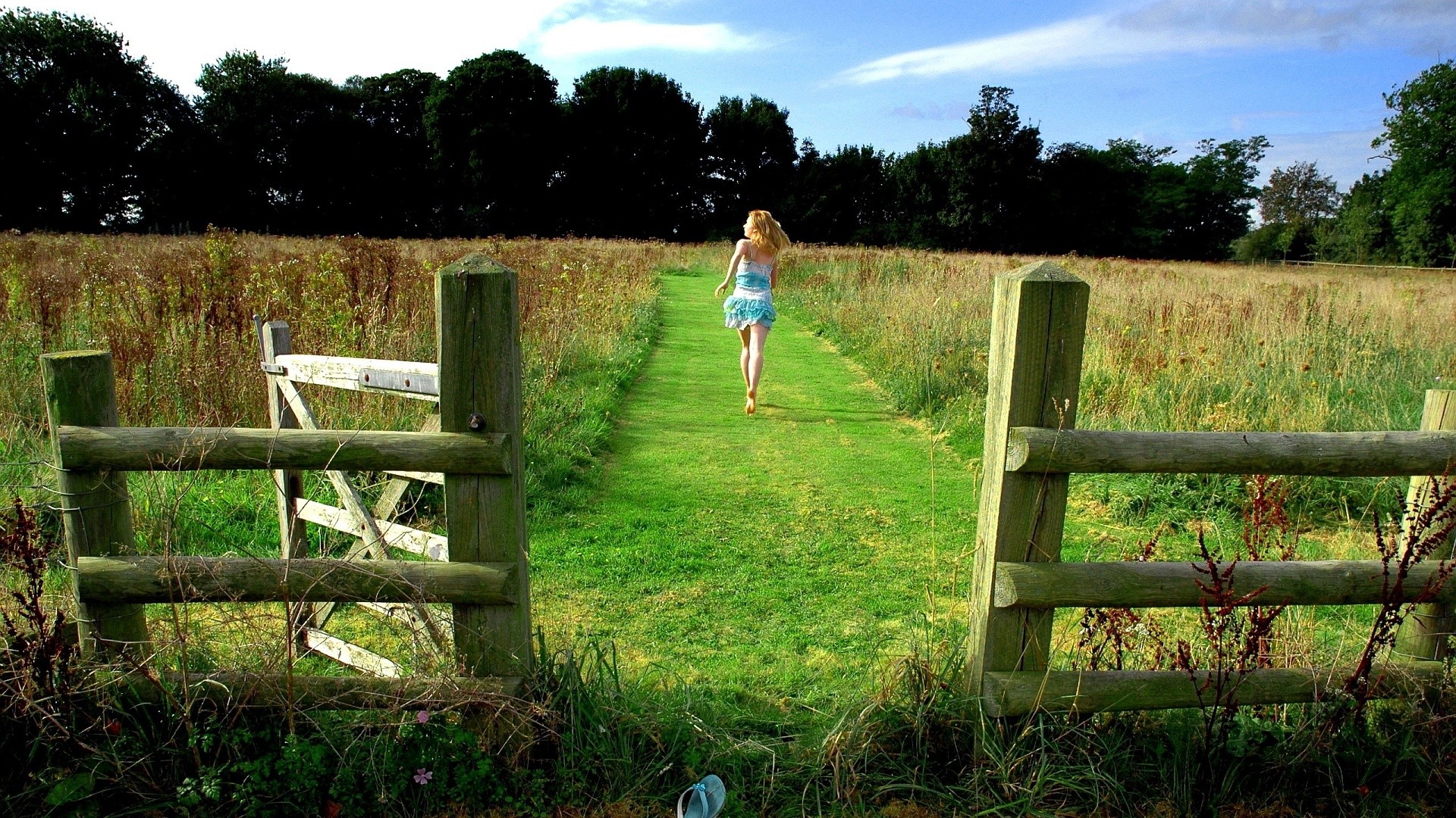 Woman running on a grassy path through a field HD Wallpaper